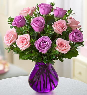 Rose Romance - When it comes to being romantic, you can never go wrong with roses! One dozen fresh, gorgeous blooms in a mix of pink and purple are hand-gathered by our expert florists in a purple glass vase to help you express all the love that's in your heart. One dozen of our freshest pink and purple roses, arranged with salal and myrtle Hand-gathered by our florists in a purple glass vase.