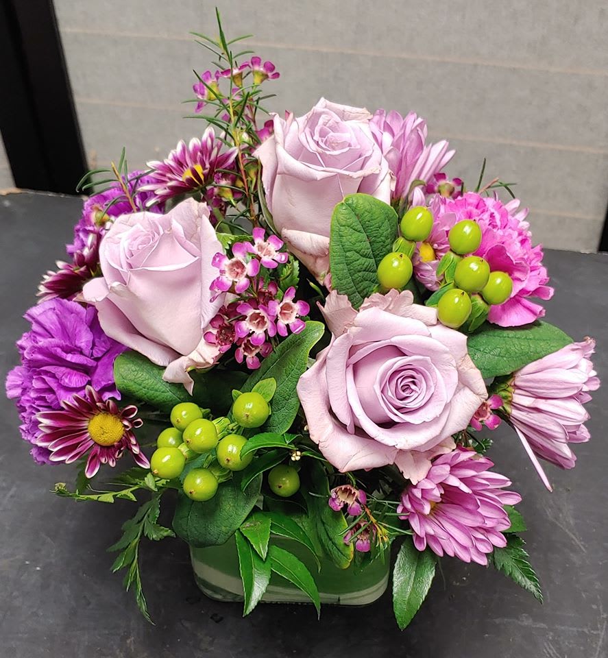 Classic cube - Delightful mixture of roses, carnations, daisies, and berries arranged in a 4x4 glass cube perfect size for an office desk, hospital room  or when you don't want something really big but want a classic assortment of flowers. Color of roses may vary we try to get as close as possible without loosing the original look and feel if the design.
