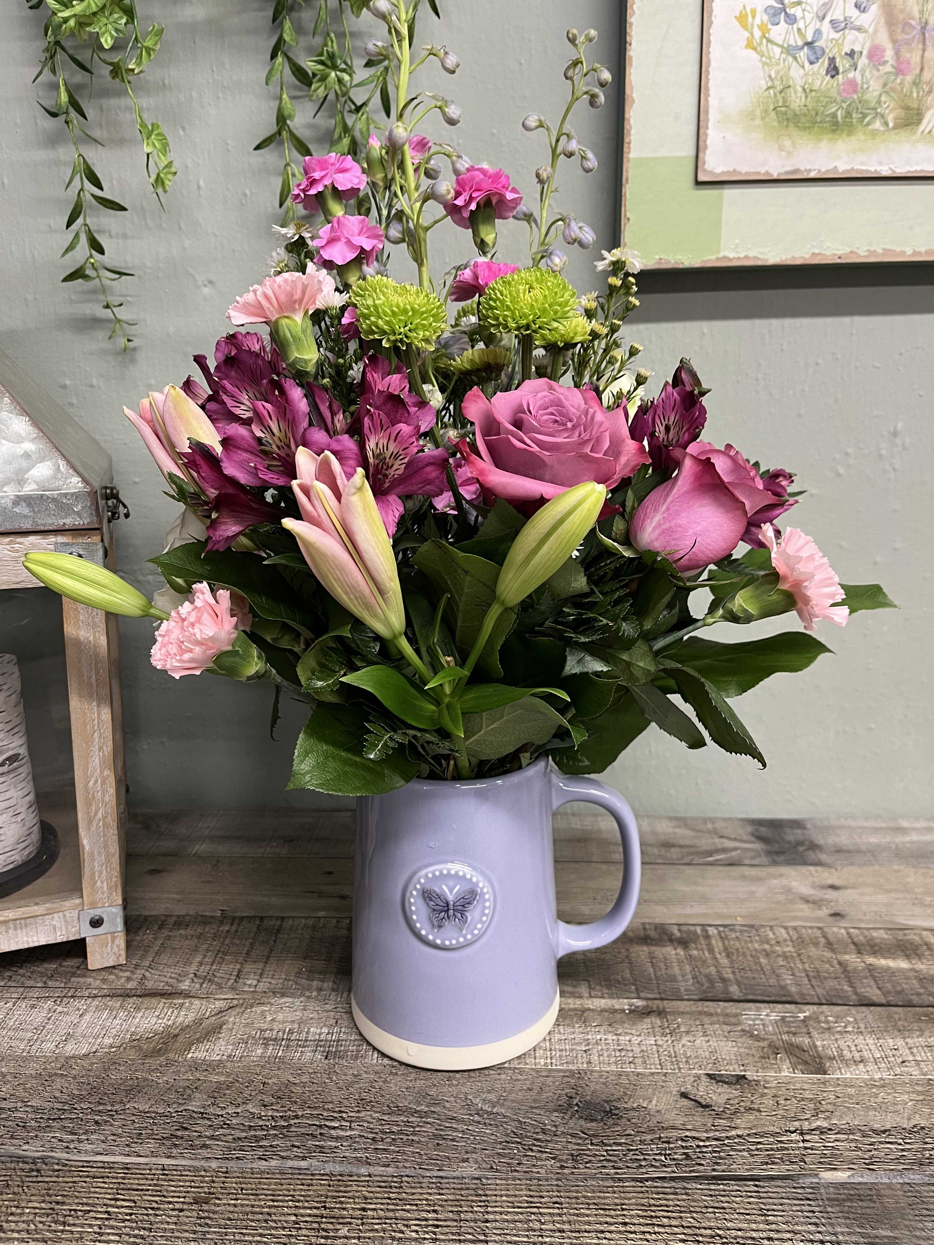 Sweetest Flutter - This cute ceramic pitcher with an embossed butterfly on the front is filled with our freshest blooms in designer’s choice of colors and styles. This keepsake container is a lovely gift for a special thank you, or for that special person in your life.  Makes a lovely gift, the keepsake pitcher is versatile for year round use. An all around design. 