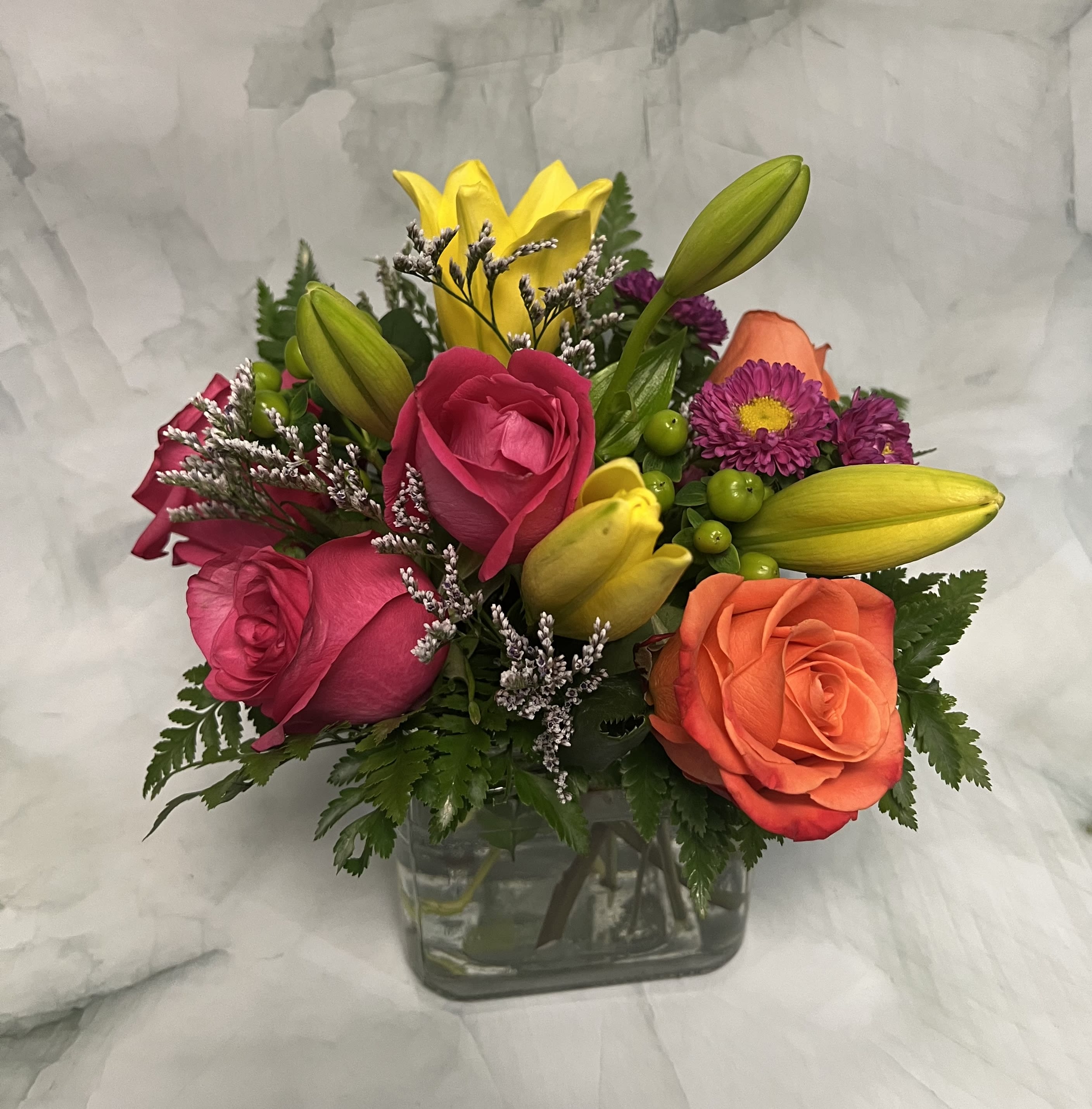 Splash of Fun - Splash in and have some fun with this colorful arrangement. This includes Lilies, Roses, Hypericum Berries, Aster Matsumoto, and Limonium. 