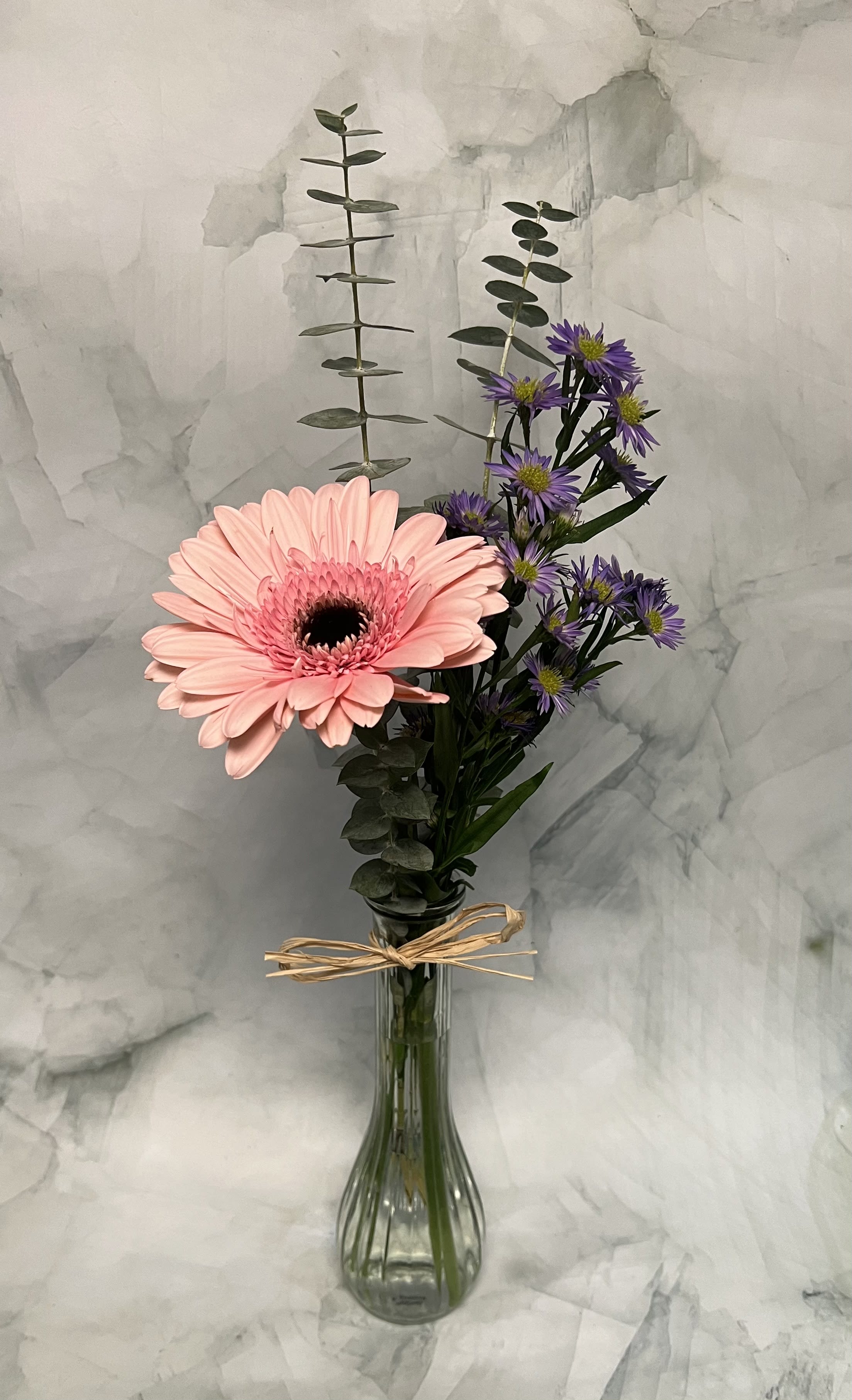 Daisy Duke - This arrangement is simple yet adorable. This includes a single Gerbera Daisy, a touch of monte casino and a touch of Eucalyptus. 