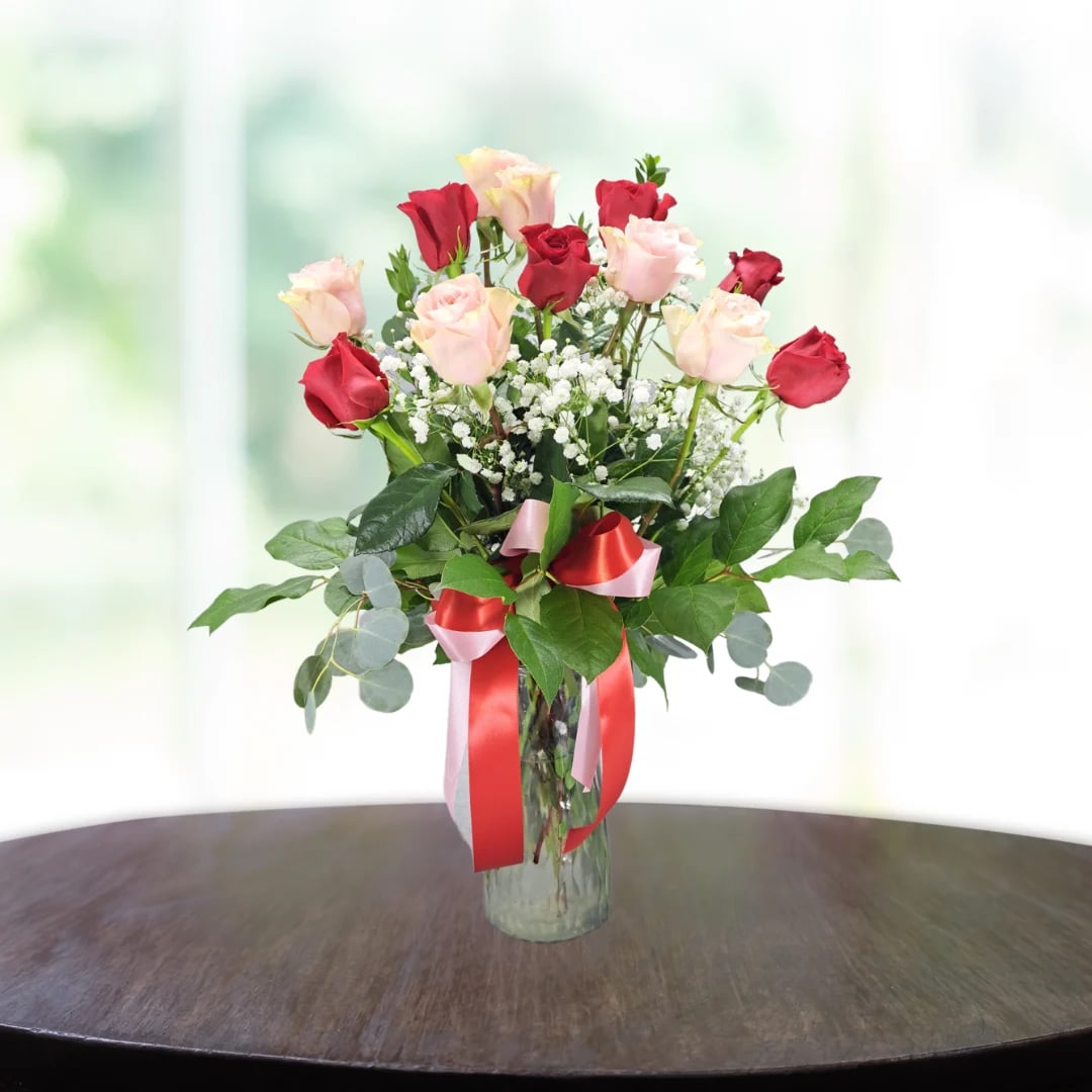 12 Long Stemmed Red &amp; Pink Roses - A red and pink ribbons tied clear vase composition arranged with 12 long stemmed premium quality red and pink roses, baby's breath, and eucalyptus.