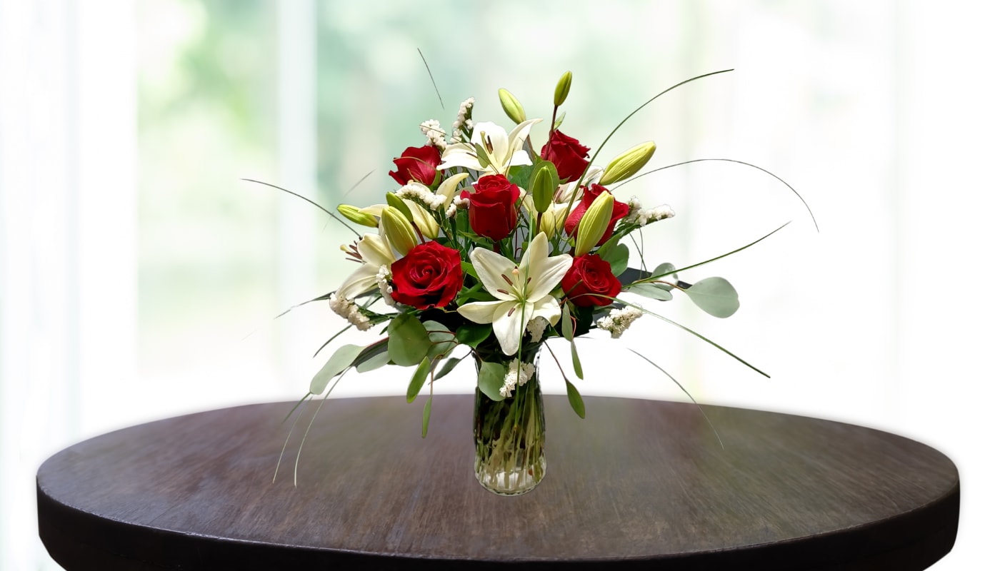 Lilies Vase Flower Arrangement - The Lilies Vase Flower Arrangement evokes the most pleasant of emotions. Whether you're looking for something striking and bold, or sweet and demure, this gorgeous vase setup is the perfect match for anyone. Arranged with white lilies, red roses, and elegant eucalyptus leaves - it's sure to be a beautiful addition to any space. A thoughtful way to show your appreciation or surprise someone special on their birthday, anniversary, or holiday season. Guaranteed to create an unforgettable wow moment and bring a smile of joy to anyone who receives it. Choose ABM Floral Studio for all your floral needs today.