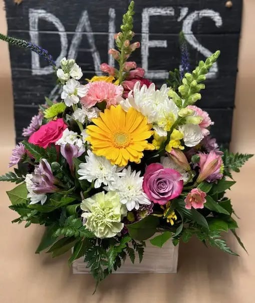 Joyful Joyful - Colorful arrangement created using our freshest flowers. Made with blooms of lavender roses, gerbera Daisy, bright carnations, colorful alstroemeria, white cushions, snapdragons, stock, buttons and various greenery. All designed in a wooden box for your keepsake.