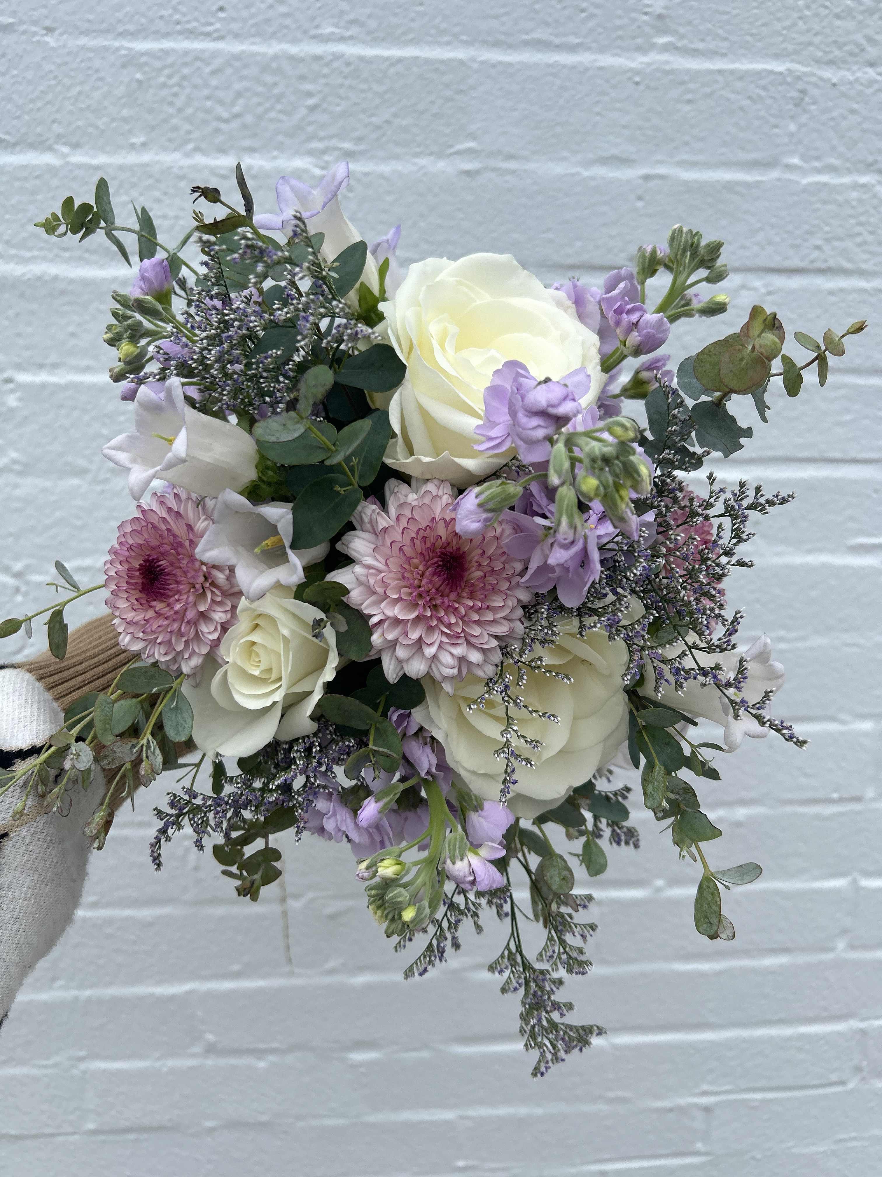 Whimsical Lavender Prom Bouquet - A designer's choice bouquet of lavender and white seasonal flowers will be created. Lavender ribbon will finish leaving the stems partially exposed.