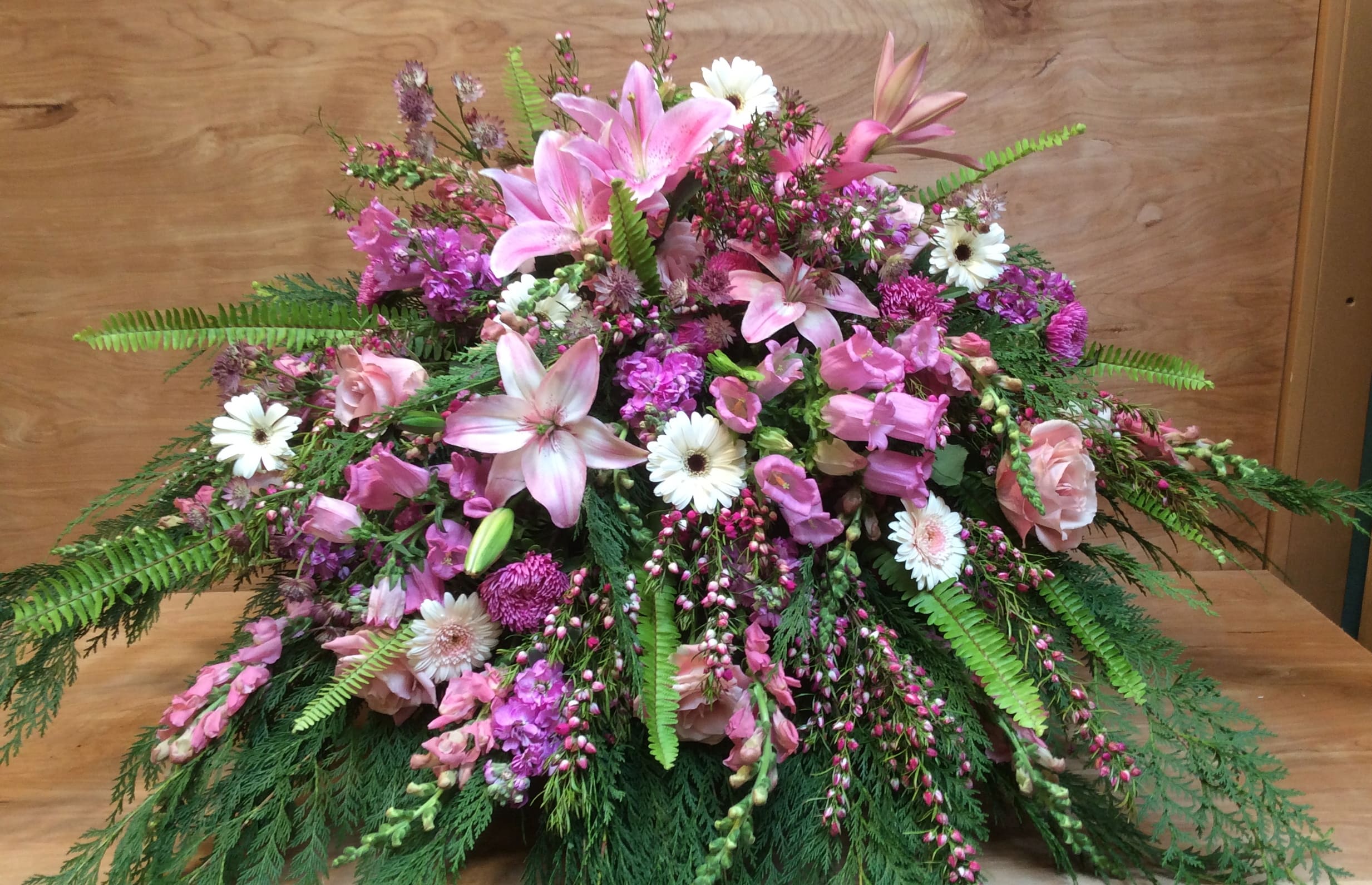 Pink Casket Blanket Pink Casket Blanket - A wonderful tribute to a loved one, an array of lilies, roses, snapdragons, alstroemeria, stock and seasonal flowers are thoughtfully arranged to create this one of kind sympathy casket blanket.