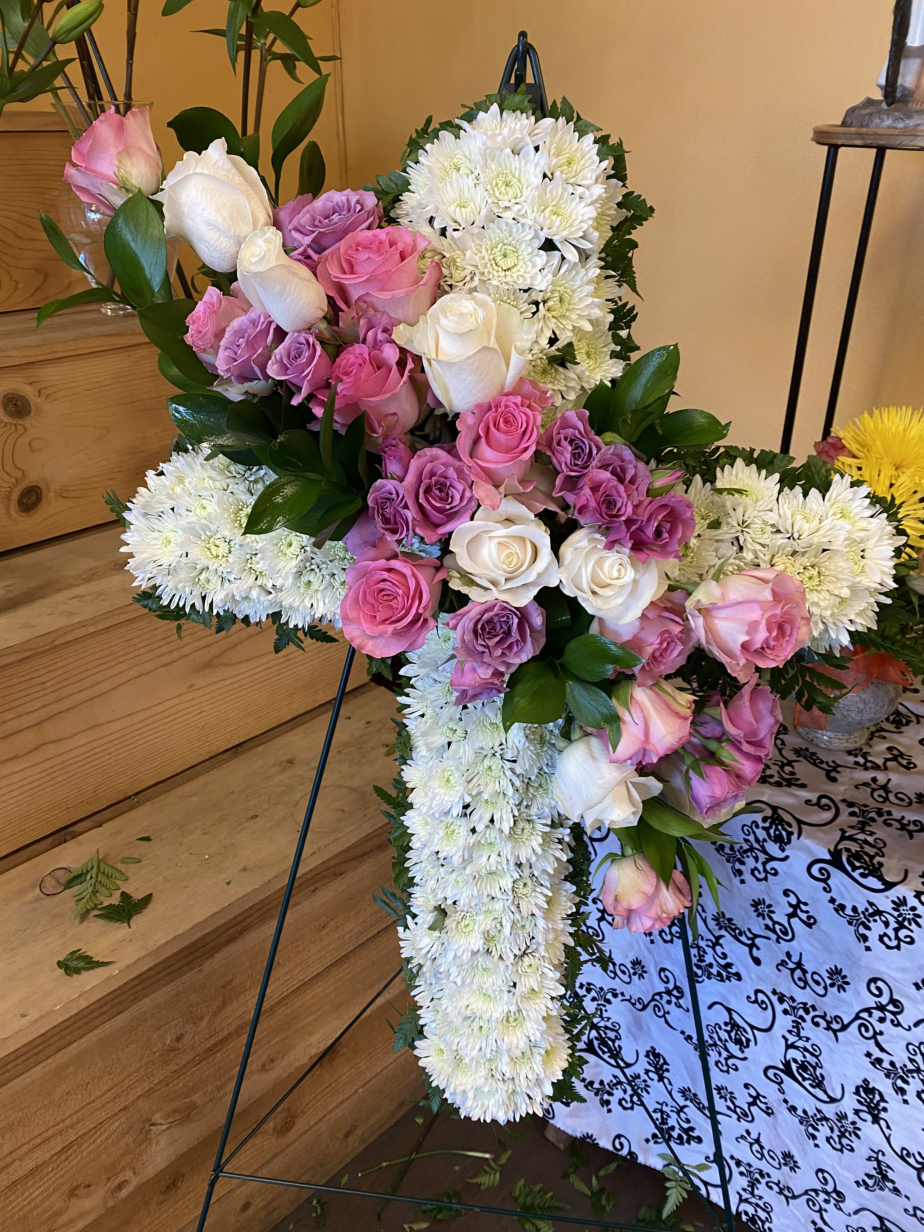 PURPLE, WHITE & PINK ROSE CROSS PURPLE, WHITE & PINK ROSE CROSS - CROSS WITH PURPLE ROSES IN THE CENTER WITH GREENARY AND WHITE CUSHION. REGULAR PRICE IS A 20 INCH CROSS DELUXE PRICE IS A 30 INCH CROSS. PREMIUM PRICE IS A 36 INCH CROSS
