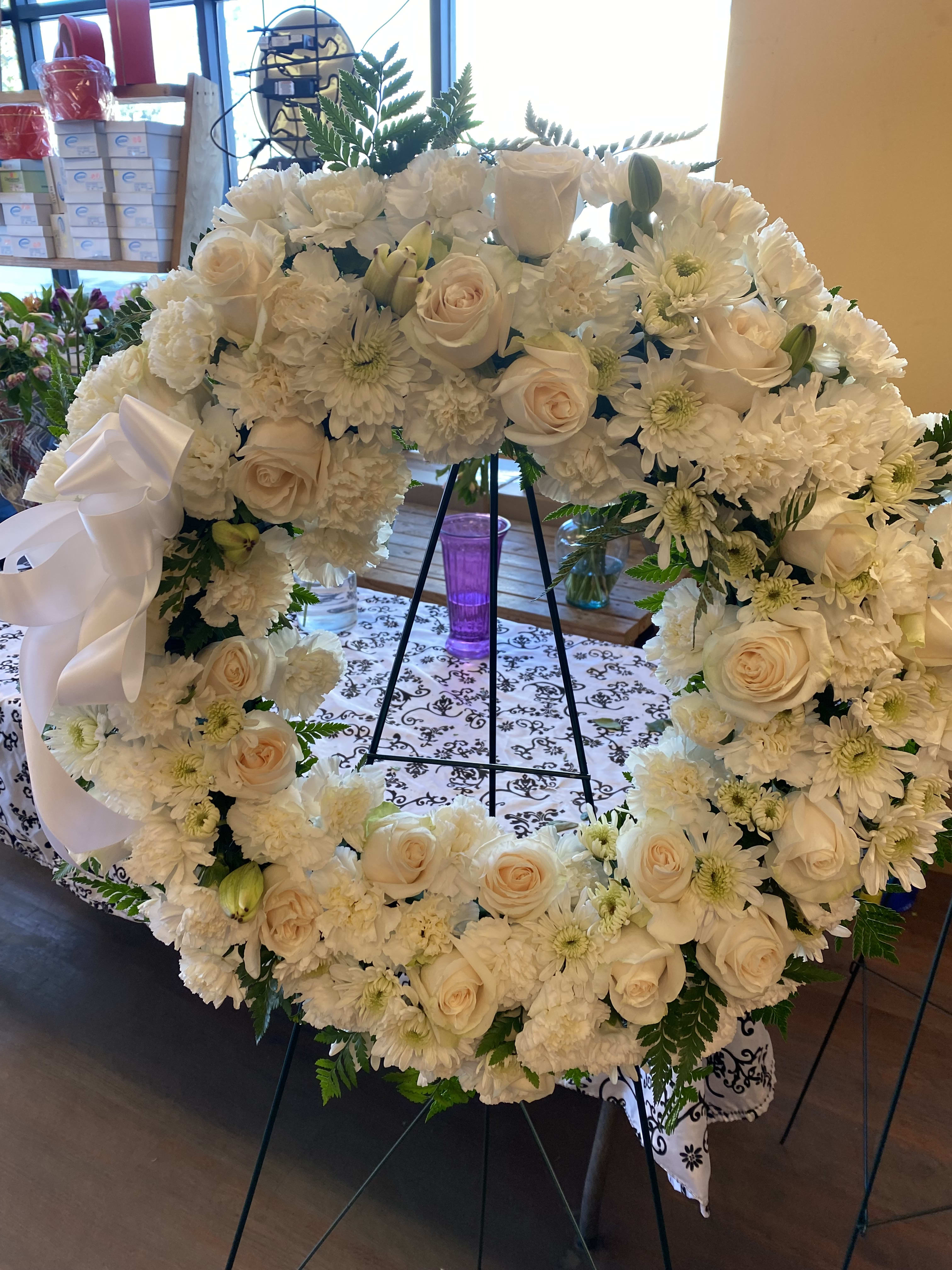 ALL WHITE WREATH ALL WHITE WREATH - WREATH WITH WHITE ROSES, WHITE CARNATIONS, WHITE CUSHION AND WHITE LILIES REGULAR PRICE IS AN 18 INCH WREATH with 25 roses and other flowers DELUXE PRICE IS A 22 INCH WREATH with 36 Roses and other flowers PREMIUM PRICE IS A 24 INCH WREATH WITH 42 ROSES and other flowers