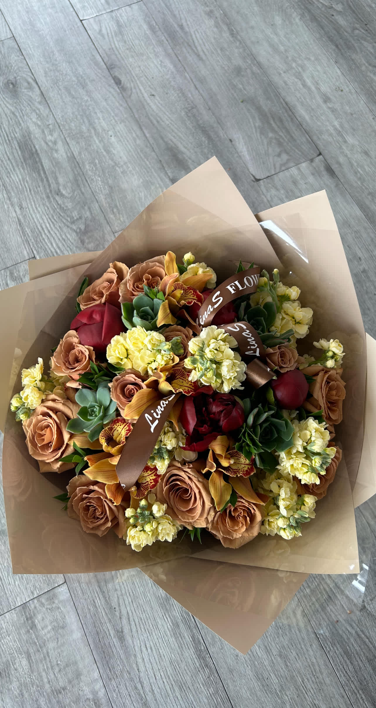 Lizi - A unique bouquet featuring earthy brown roses, exotic orchids, and striking succulents. This arrangement blends the rich, warm tones of brown roses with the sophisticated allure of orchids and the modern, textured look of succulents, creating a captivating and contemporary display.
