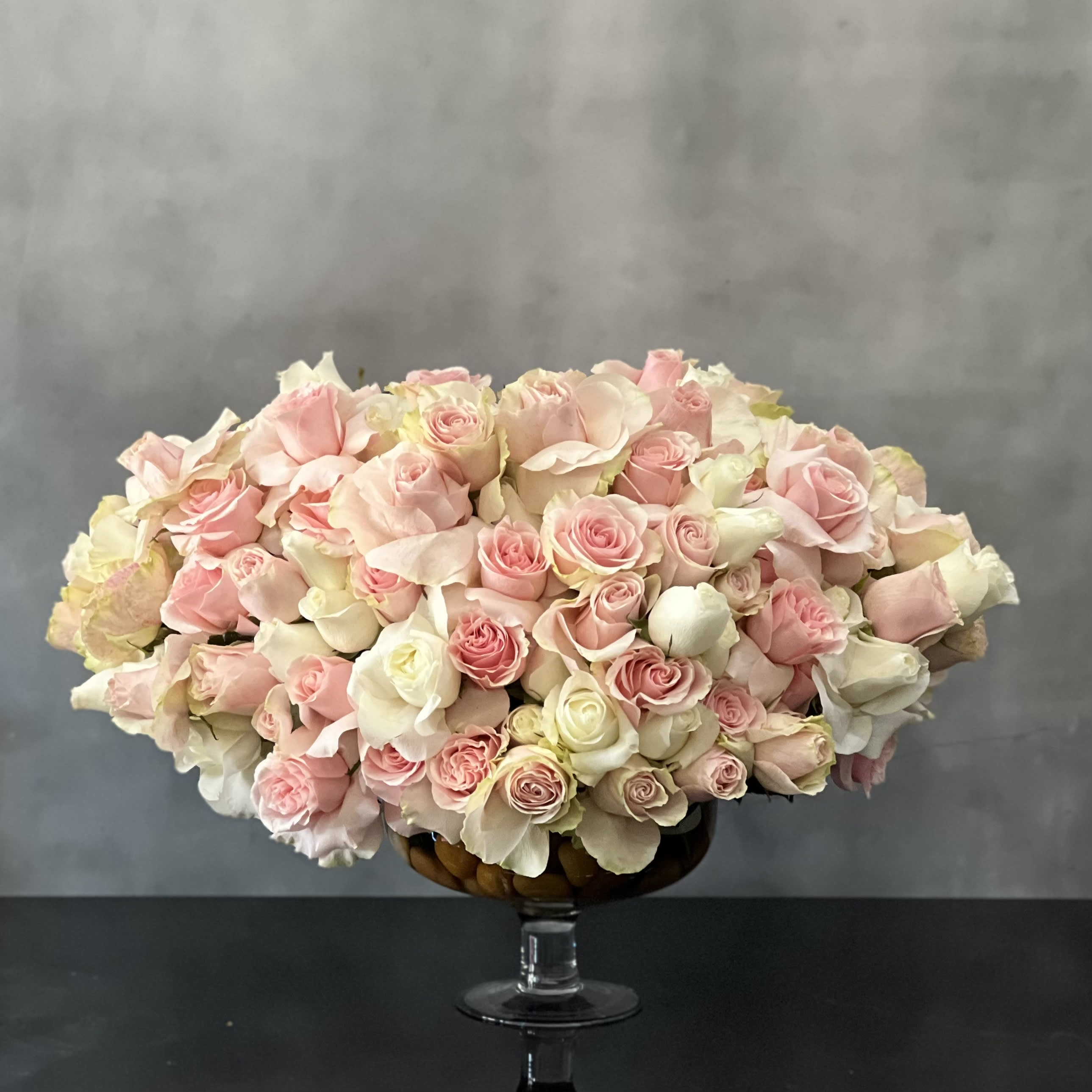 Passion in Pink - Designed to be the ultimate expression of your affection. over 100 stem Light Pink  and white South American Roses are exquisitely arranged in a container. This is sure to leave an impression that's impossible to forget!  