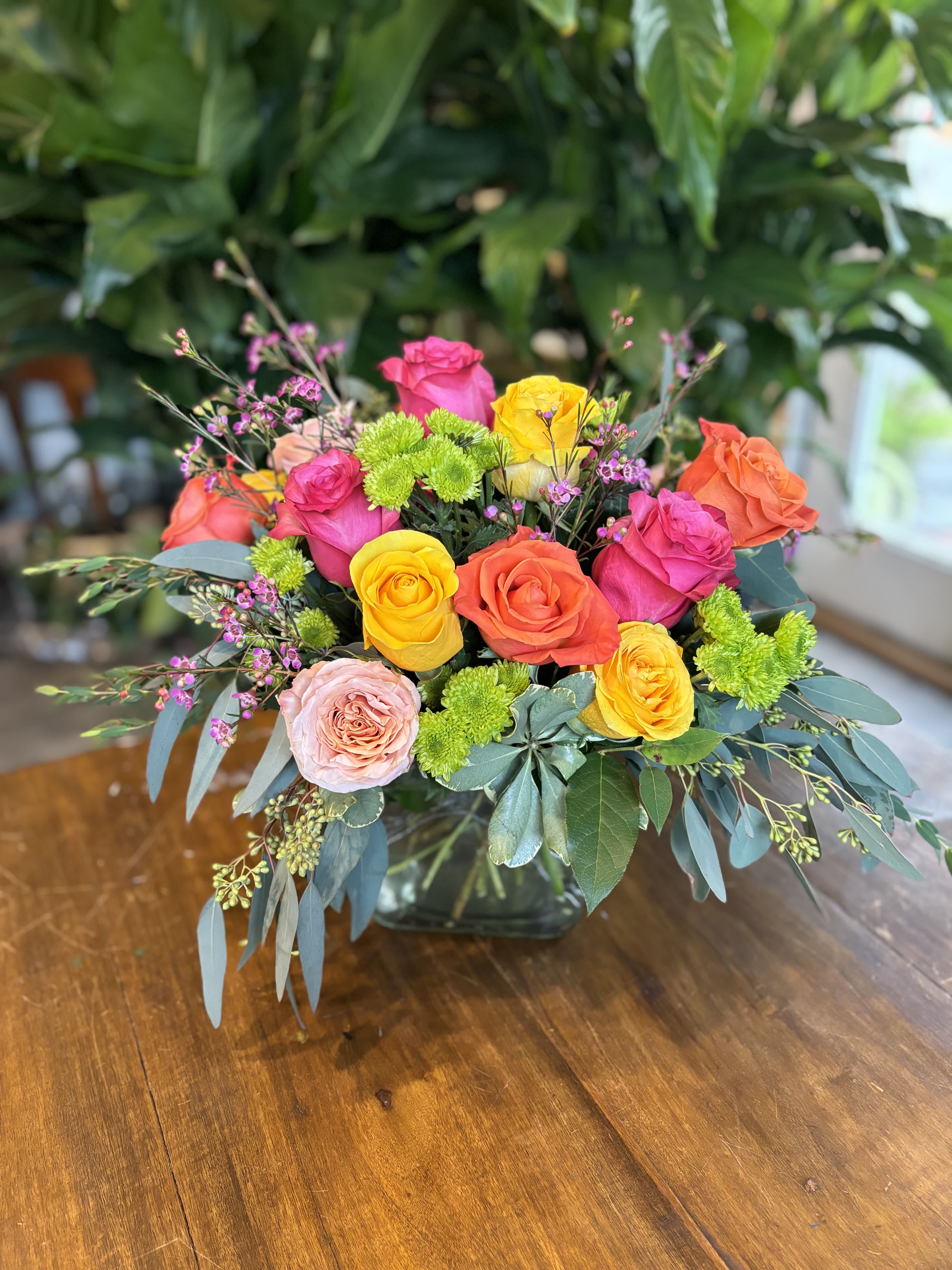 Vibrant Blooms - 18 of our brightest roses in a cube vase, springing with eucalyptus and other bright florals. 