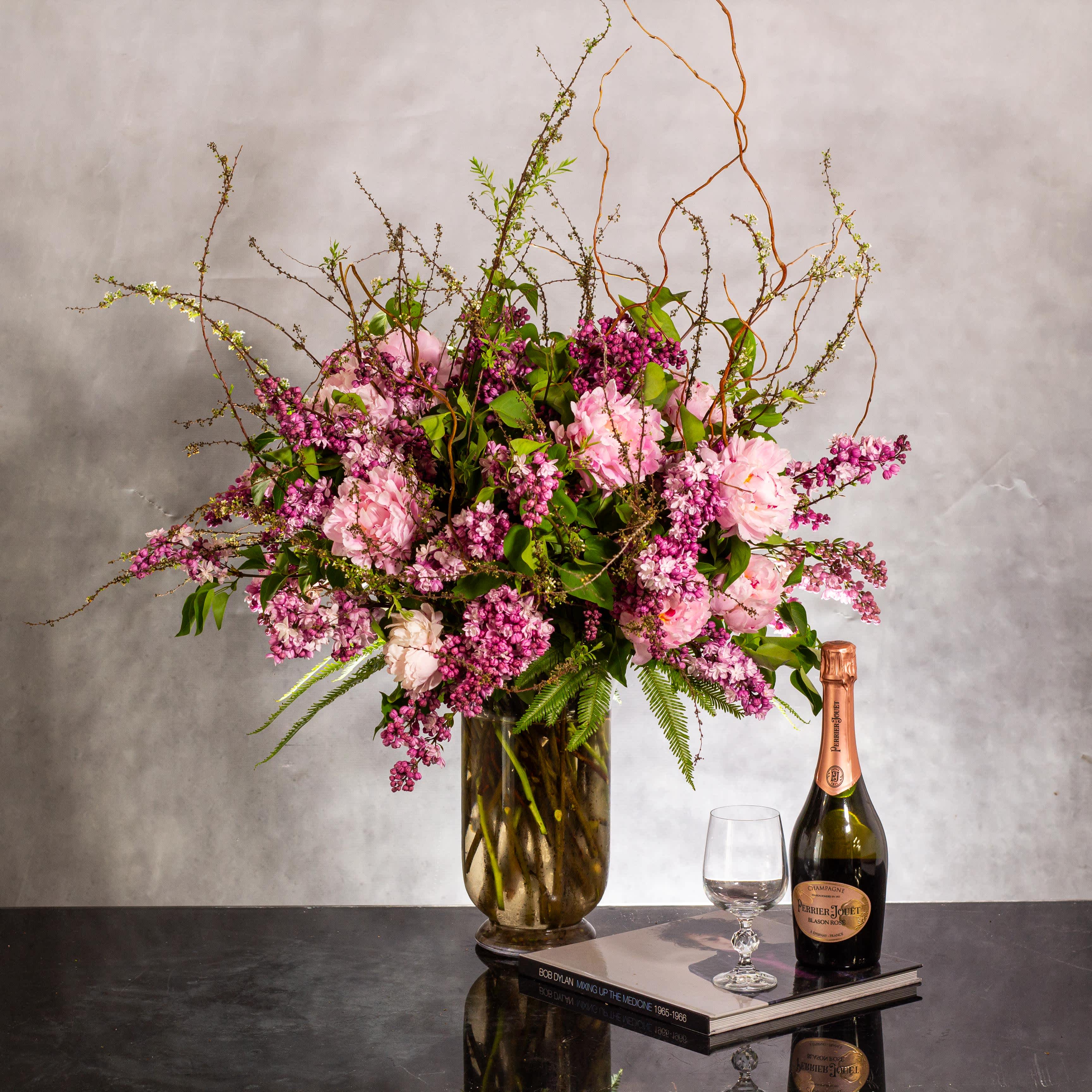 Captivating Lilacs and Peonies - Enchanting Blossoms Display - The grand display features an organic arrangement of fragrant lilacs, peonies, and Curly Willow in a vase, creating a stunning showcase of spring blooms. Standing tall at 28 inches and spanning 22 inches wide, this arrangement is truly captivating and will bring the essence of spring into any space. Perfect for creating a wow effect, these beautiful blooms are available for same-day delivery in Beverly Hills, allowing you to bring the freshness of spring right into your home.
