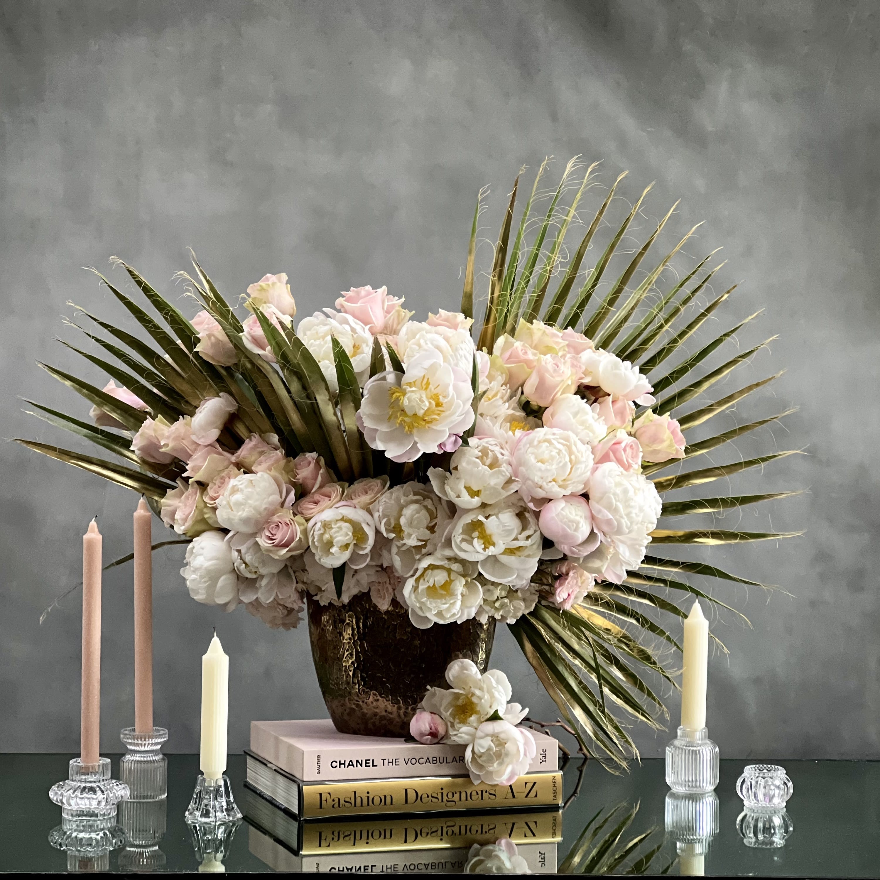 Peony Drama - Step into a world of enchantment with our breathtaking creation: a dramatic mix of pink peonies and garden variety roses, expertly curated by the team at My Beverly Hills Florist. Delight in the beauty of these exquisite blooms, carefully arranged to captivate the senses and evoke a sense of awe and admiration.  Measuring an impressive 24 inches wide and standing tall at 27 inches, this stunning floral arrangement commands attention with its sheer grandeur and elegance. Each peony and rose is hand-selected for its unparalleled beauty and freshness, ensuring that every petal exudes the essence of luxury and refinement.  Presented in an opulent gold vase, this arrangement adds a touch of glamour and sophistication to any setting. The oval shape of the vase lends a sense of grace and fluidity to the composition, enhancing the overall visual impact of the display.  At My Beverly Hills Florist, we understand the importance of expressing love and appreciation with style and flair. That's why we offer same-day delivery for this exquisite creation, allowing you to convey your heartfelt sentiments to the special person in your life without delay.  Whether it's a gesture of love, gratitude, or celebration, this stunning arrangement is sure to leave a lasting impression. Trust My Beverly Hills Florist to deliver not just flowers, but a masterpiece of floral artistry that speaks volumes without saying a word.