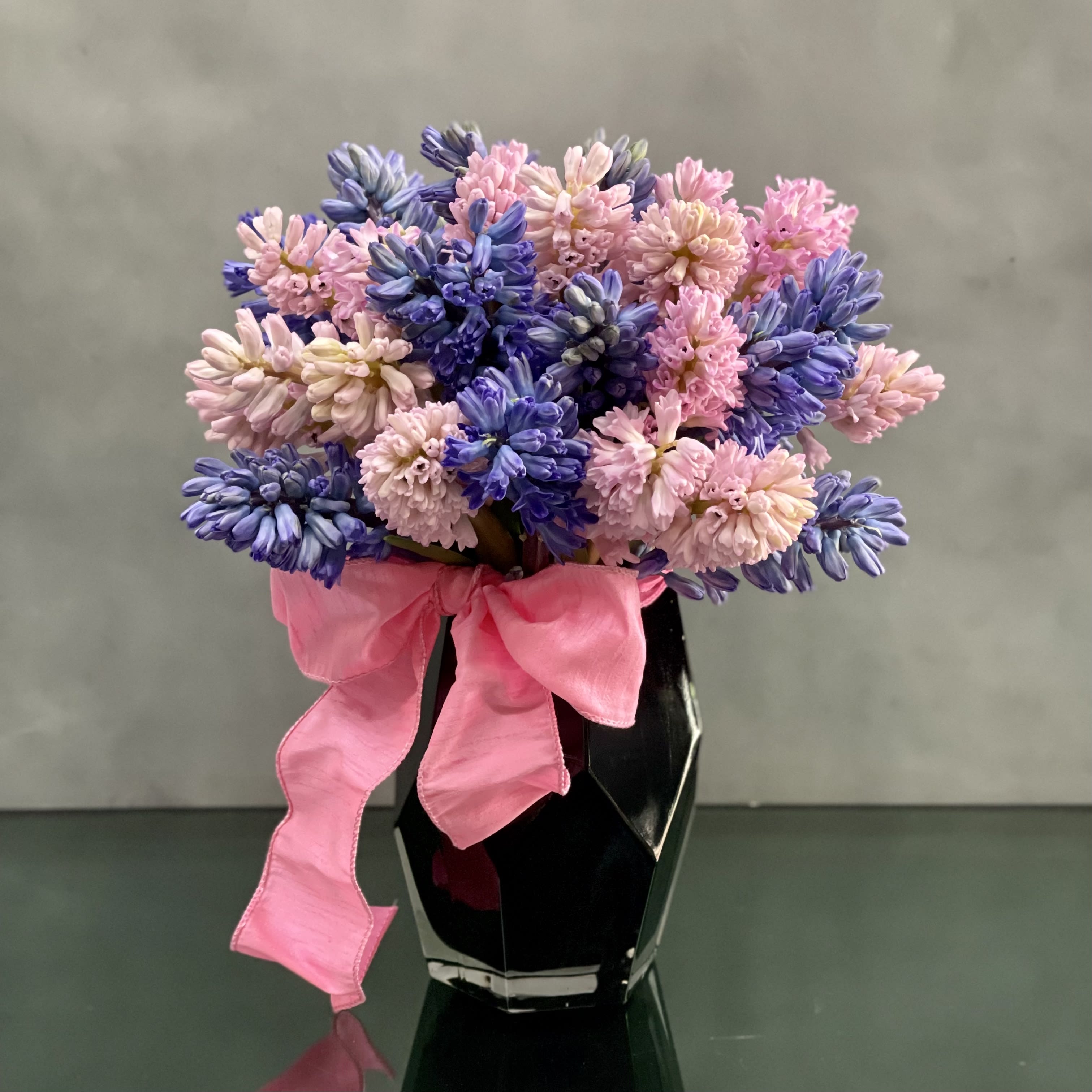 Hiya! Hiya! - Bold and Beautiful. Enjoy the sweet smell of colorful hyacinths in a black geometric medium vase. Substitutions available upon request. Standard shown