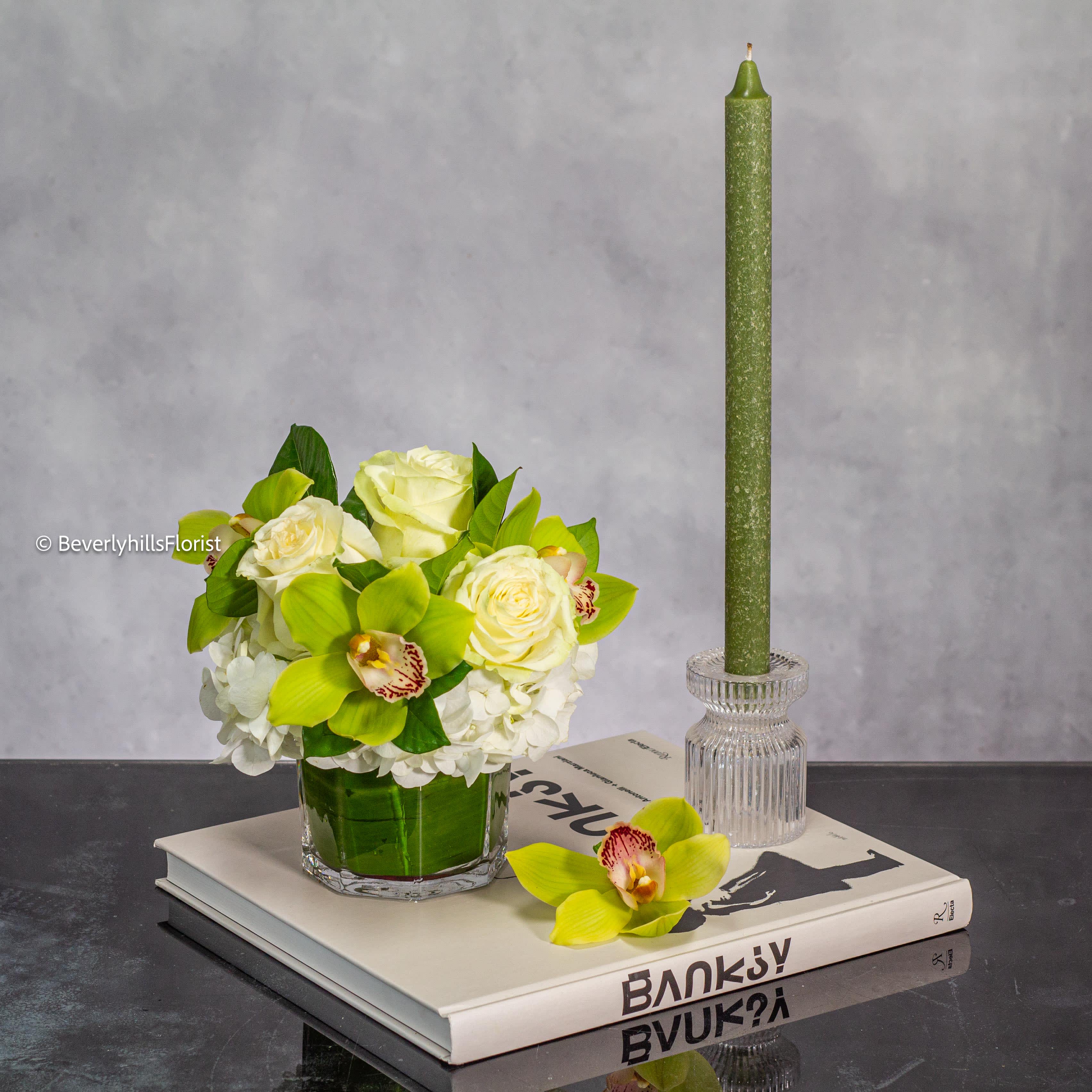 Dainty Duet - Sometimes something small and sweet is all you need to say a million words for a million reasons. We love this little duo showing off a petite selection of White Roses and Pistachio Green Cymbidium Orchids in a clear glass vase. Perfect for a desk or tableside.