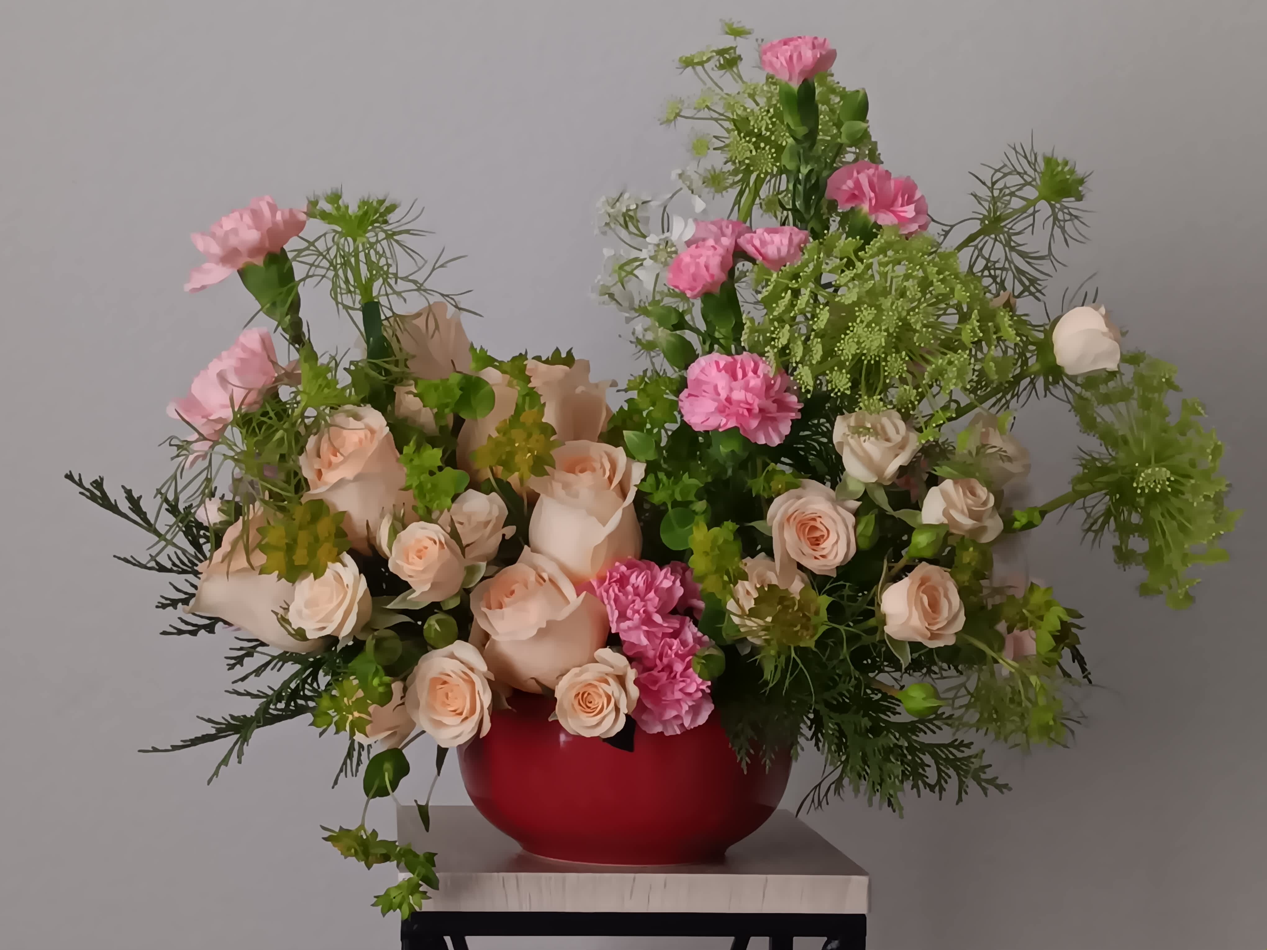 Rosy Skies  - Illuminate love, embracing soft pastel shimmer and cradling an exquisite bouquet of vibrant pink flowers, a timeless expression of artistic beauty for any occasion. Embrace enchantment with  Rosy Skies Bouquet, a delicate bouquet of light pink roses, crème spray roses, miniature pink carnations, Queen Anne's Lace flowers and parvifolia eucalyptus, which makes a radiant gift for any celebration. Orientation: All-Around  SUBSTITUTION POLICY – Always deliver the freshest flowers! Please note the bouquet pictured reflects our original design.  If the exact flowers or container in this arrangement are not available, our local florists will create a beautiful bouquet with the freshest available flowers.