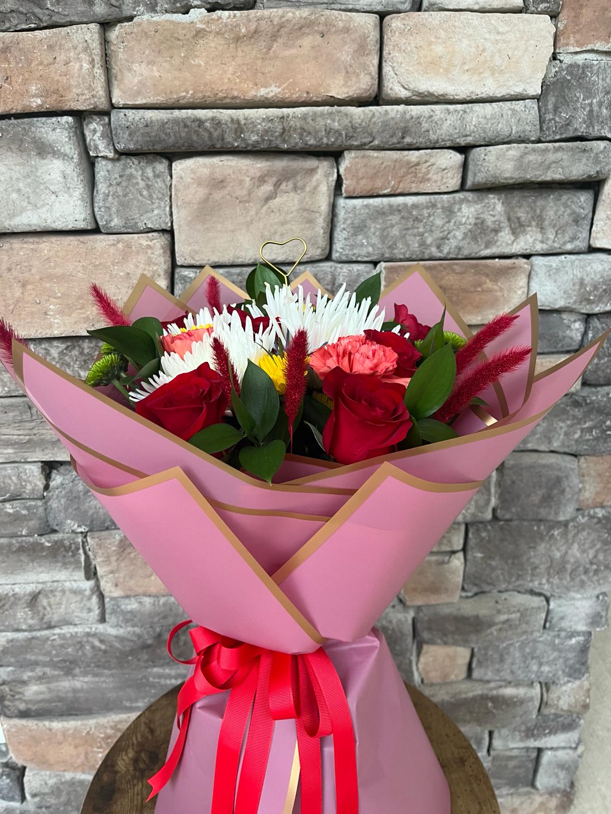 Crimson &amp; Cream - Unveil the timeless elegance of red and white in this enchanting paper floral bouquet. Each bloom, meticulously handcrafted from delicate paper, captures the intricate beauty and enduring charm of nature's finest blossoms. Vivid red roses, symbolizing love and passion, intertwine with pristine white lilies, representing purity and devotion. Delicate anemones and playful carnations add pops of texture and personality, while sprigs of greenery and paper leaves create a natural backdrop for this captivating arrangement. Presented in a decorative paper wrap, this bouquet is a unique and everlasting gift, a testament to the enduring beauty of love and the artistry of papercraft.