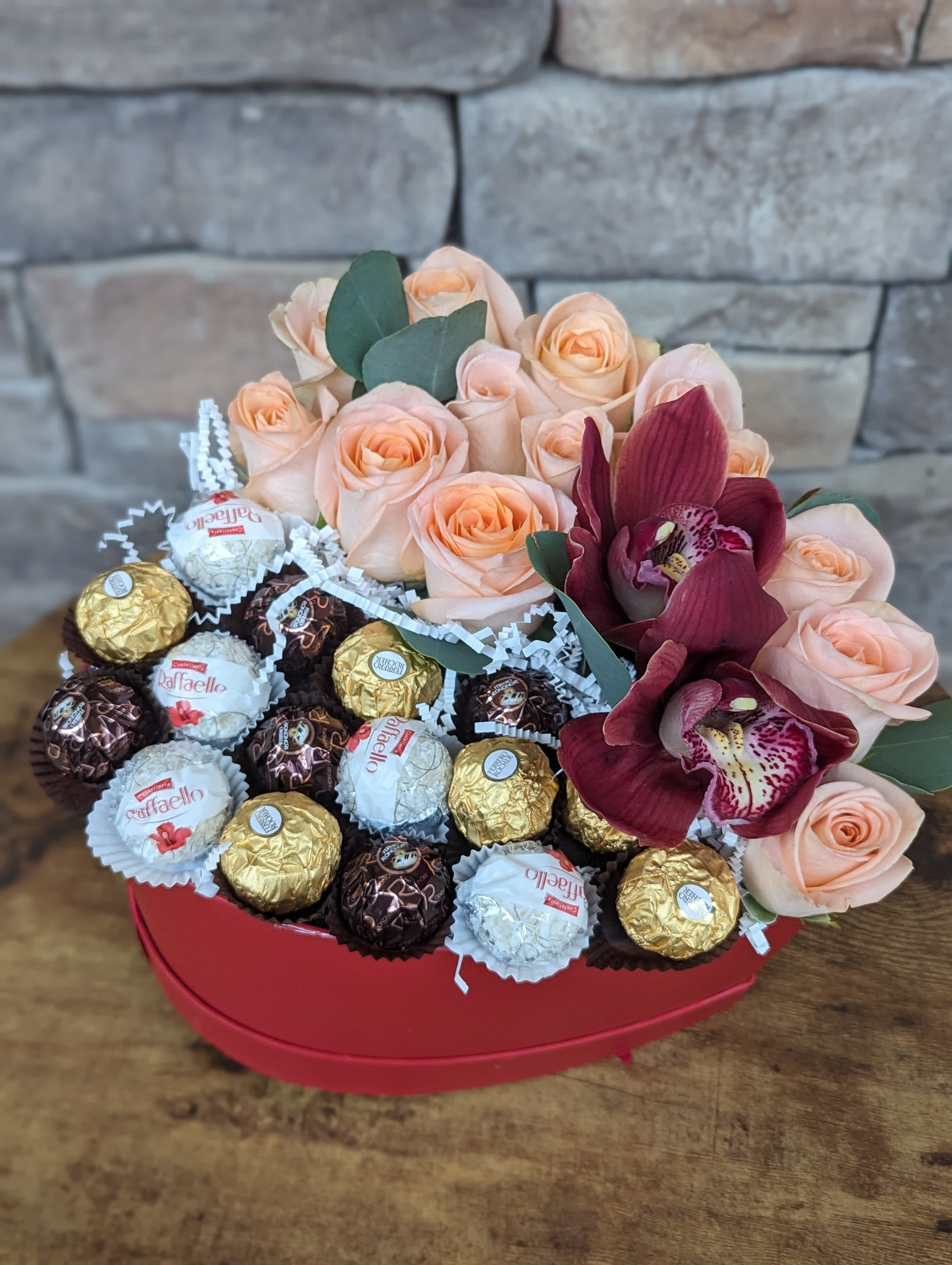 Bella Notte - Bella Notte: A Romantic Treat from Italy  Celebrate your love in style with our Bella Notte Love and Romance gift box. This heart-shaped box features a delightful assortment of decadent chocolates, sure to satisfy your sweetheart's sweet tooth. Nestled amongst the chocolates, you'll find a charming selection of fresh, seasonal blooms, adding a touch of vibrant color and natural beauty to the presentation.  Please note: The specific chocolates and flowers may vary depending on season and availability. However, you can always expect a high-quality selection that reflects the spirit of Bella Notte.