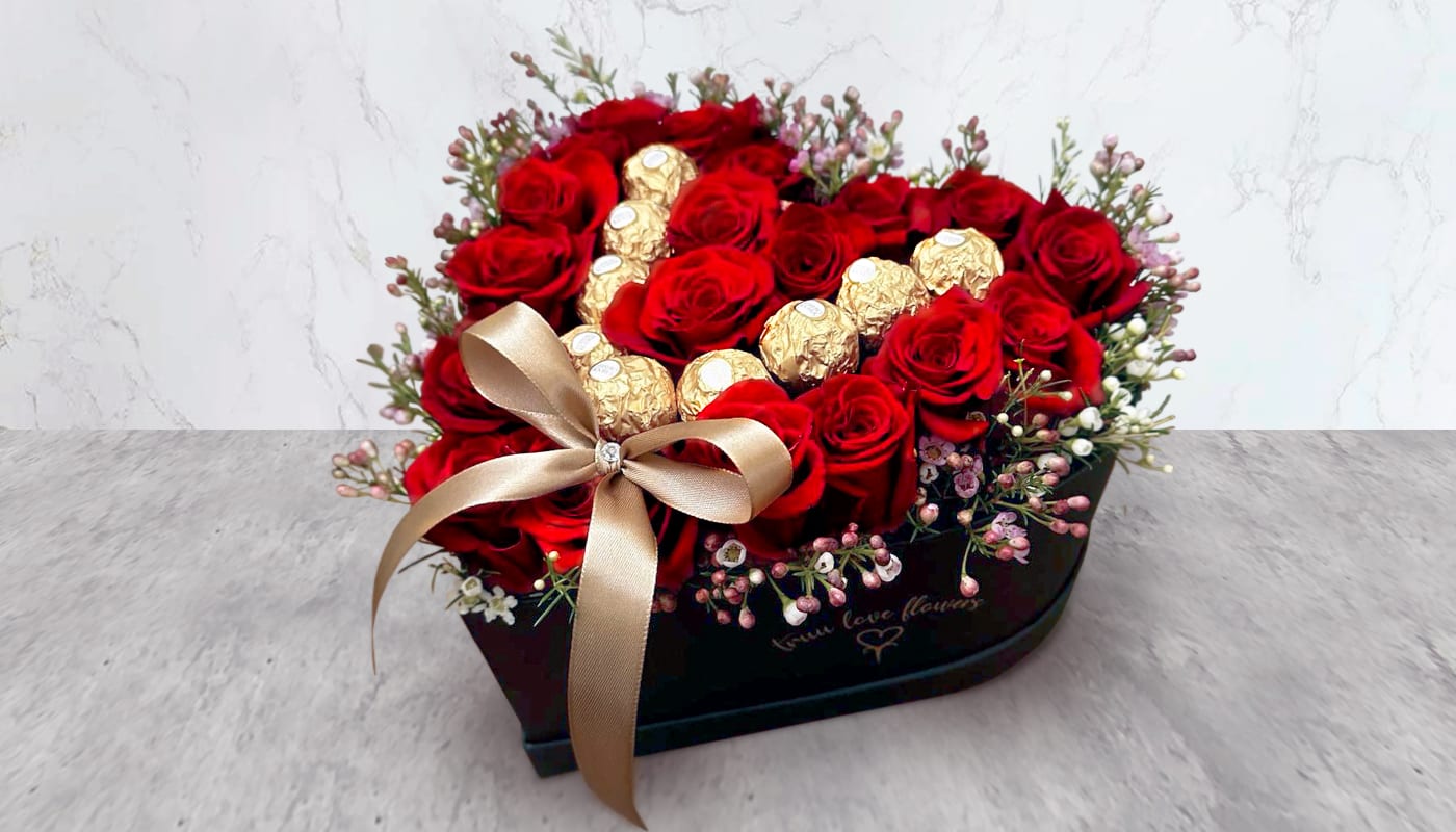 Heart Roses With Ferreros Heart Roses With Ferreros - this arrangement contains Red Roses, wax Flower & ferreros