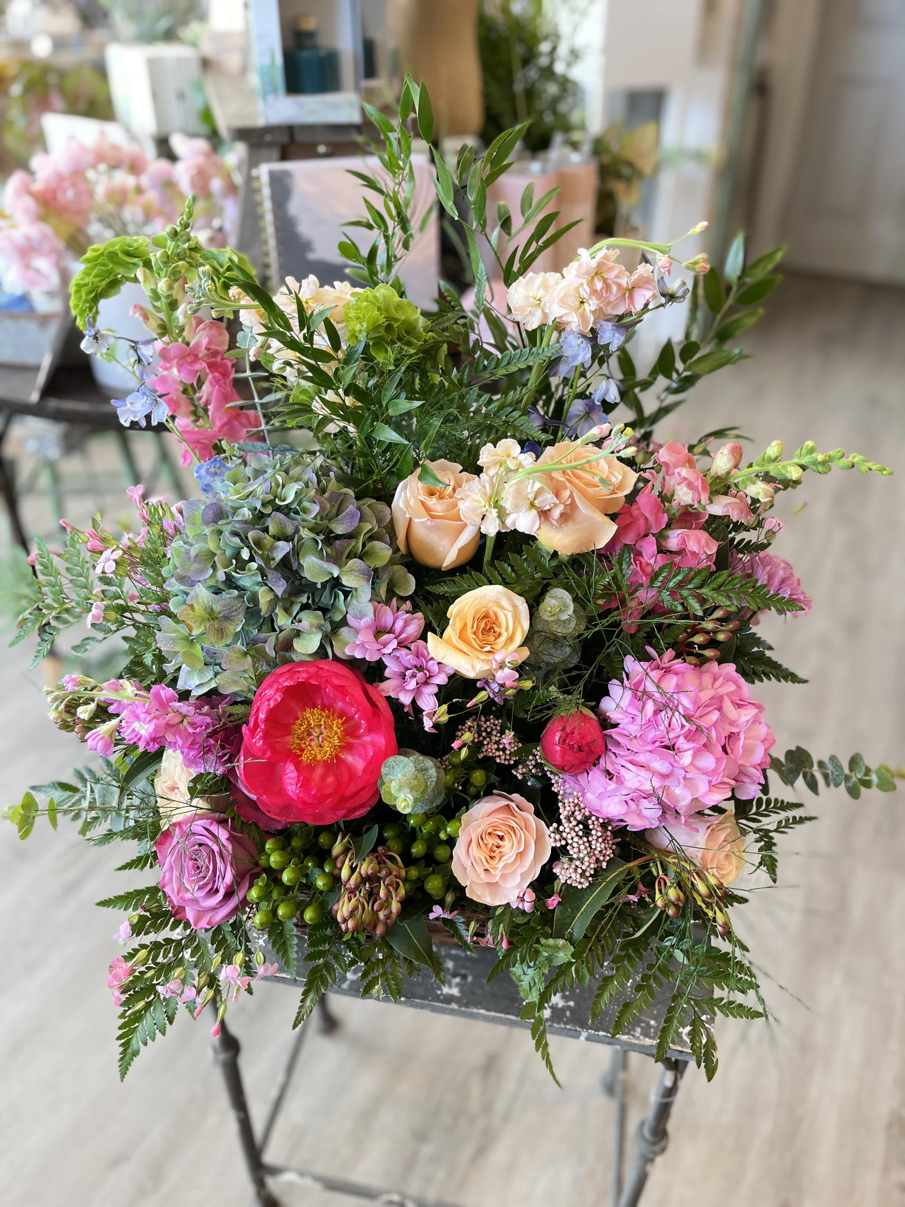 Vibrance Traditions Basket  - Celebrate the memory of a vibrant and joyful lost loved one with this beautiful sympathy basket. Our designers will incorporate colors such as purple, pinks, corals and lime greens in some of our favorite seasonal blossoms.   Please note, this piece is intended for the funeral service, and not for a residence.  Approx 32&quot; tall and wide. 