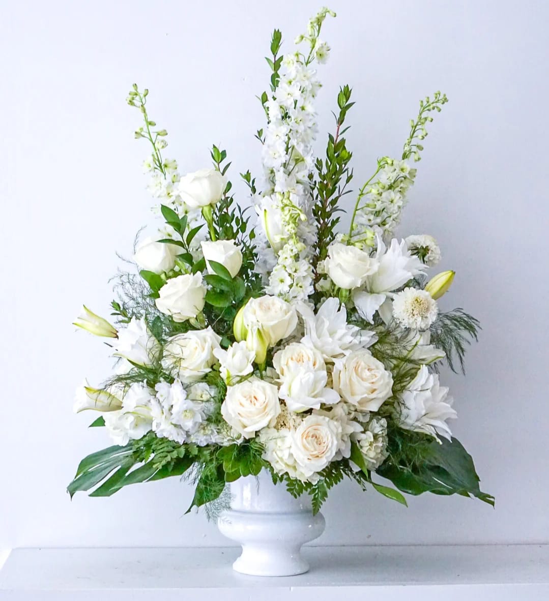 Eternal Peace  - An all-white arrangement that exudes grace and solace. With its pristine palette, this arrangement pays tribute to cherished memories with an understated elegance. The purity of white blooms symbolizes the light that lives on, offering comfort during times of loss. 