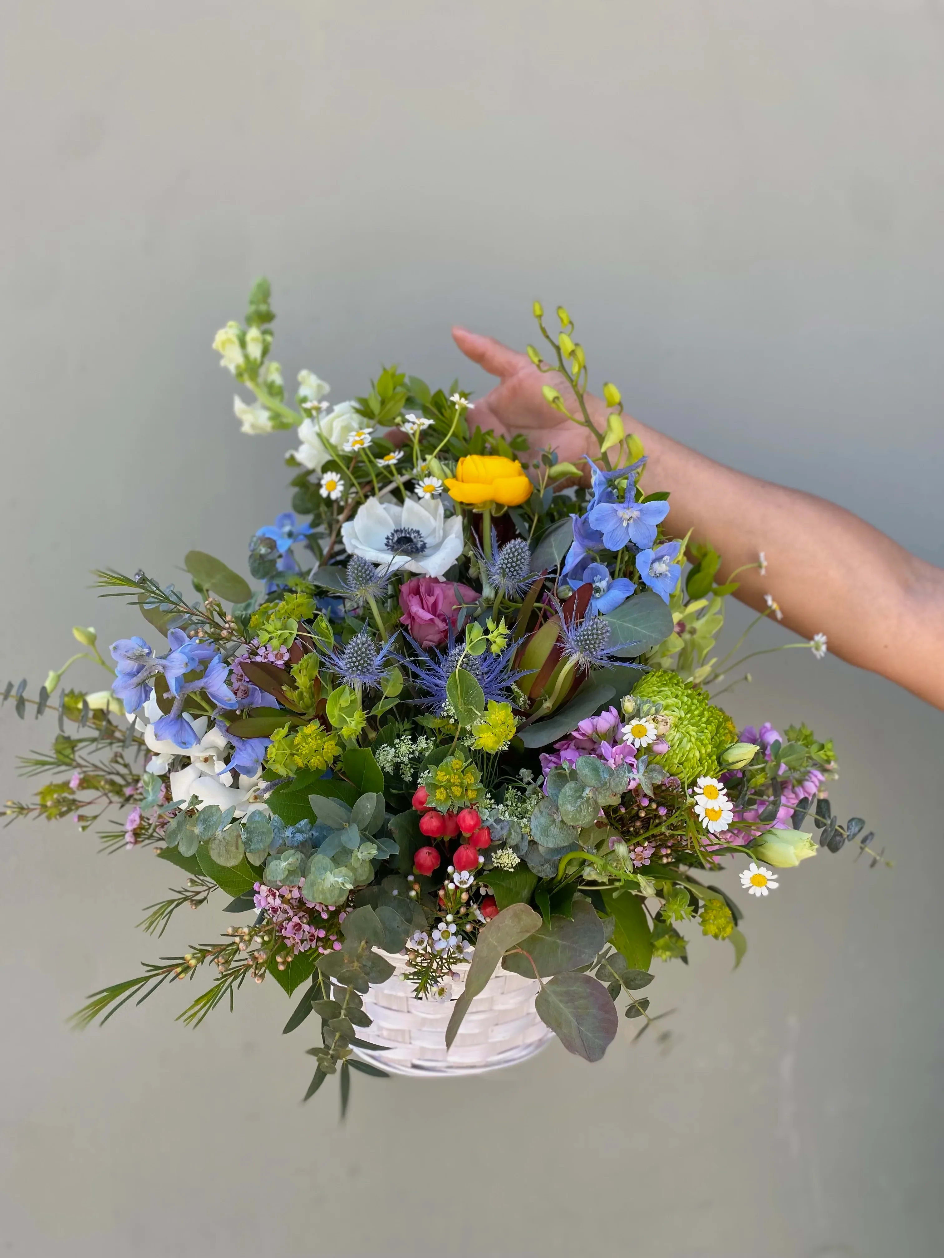 Wild Garden Basket Wild Garden Basket - This basket contains a variety of flowers and greens, including ranunculus, coffee beans, thistles, delphinium, stock, and more. Perfect for any occasion!