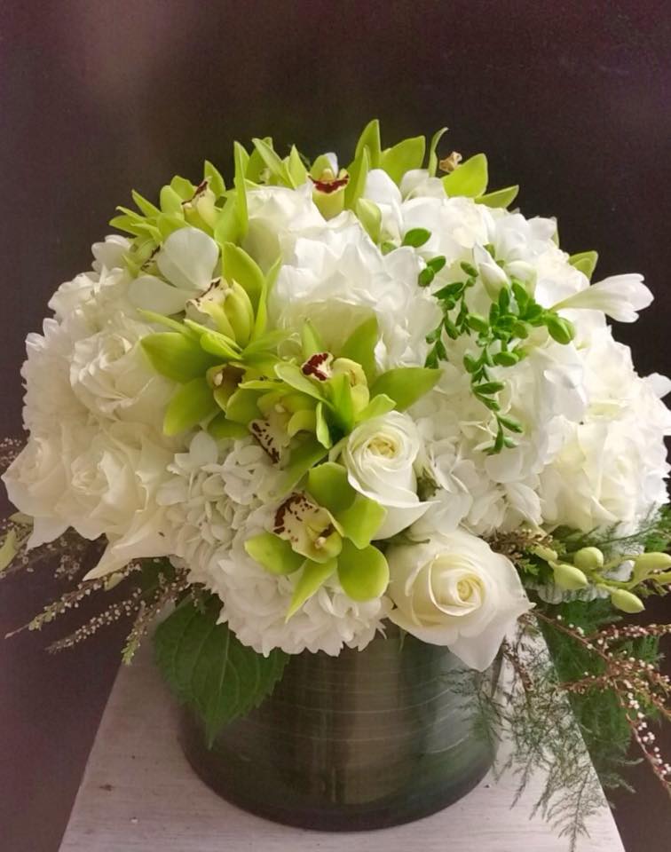 Cool Greens - Color blocking in a cylinder vase, using whites and cool greens - featuring hydrangea, Eskimo white roses, green cymbidium, white freesia.