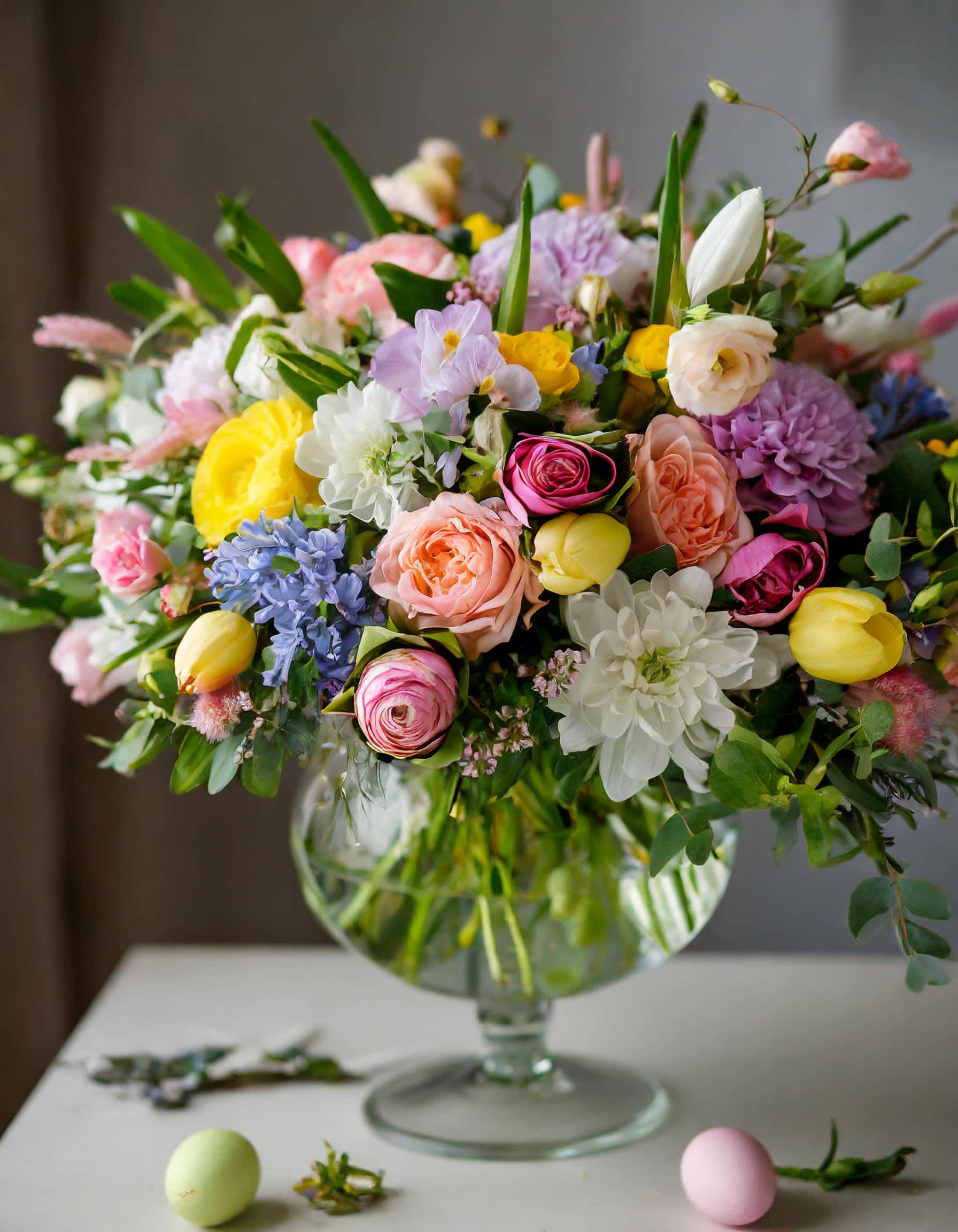 Spring  Bouquet - A clear vase with Easter's vibrant essence, a garden-style symphony in purple Hyacinths, yellow tulips, white dahlia and peach roses. It's a masterpiece of natural abundance and elegance, evoking the beauty of a sun-kissed garden in full bloom.  Recommended for:  Love and Romance, I Love You Flowers, Anniversary, Proposal, Romantic Gift, Birthday, Get Well Soon, Celebrations, Best Wishes, Thank You, Congratulations, Just Because, New Baby, Everyday, Easter, Mother's Day 