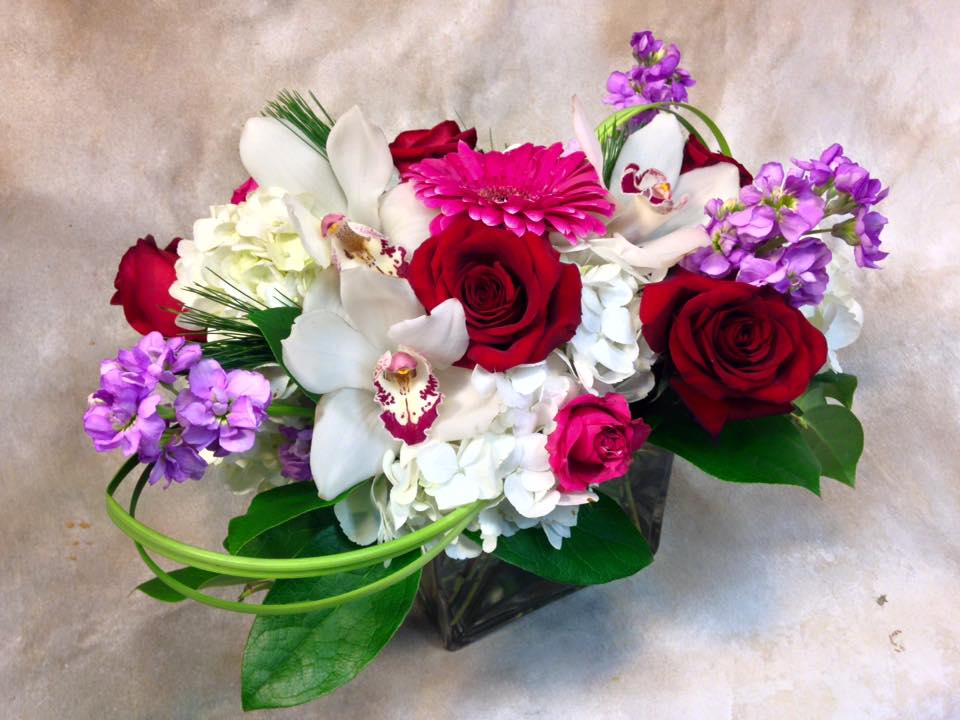 Smoochie Lips Smoochie Lips - Like a big floral kiss - orchid blossoms, stock, roses in a low rectangle vase.