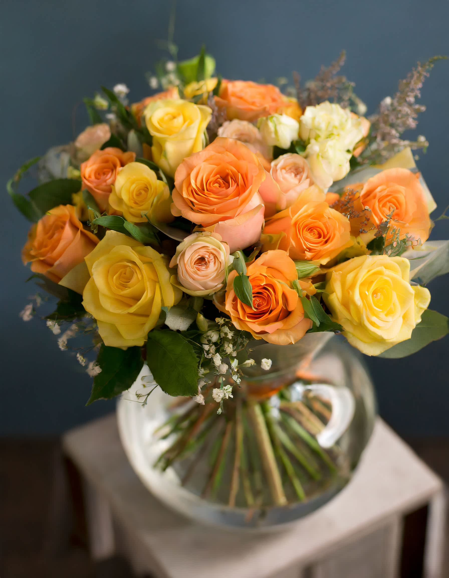 Sunny Charm - The arrangement includes radiant roses and a delightful assortment of mixed flowers, evoking a sense of brightness and sunshine.  Disclaimer: ALL IMAGES PROVIDED AT DELUXE PRICE Photos and visual presentation of the products represent an overall style, look and feel, which we may not be able to identically replicate in some instances