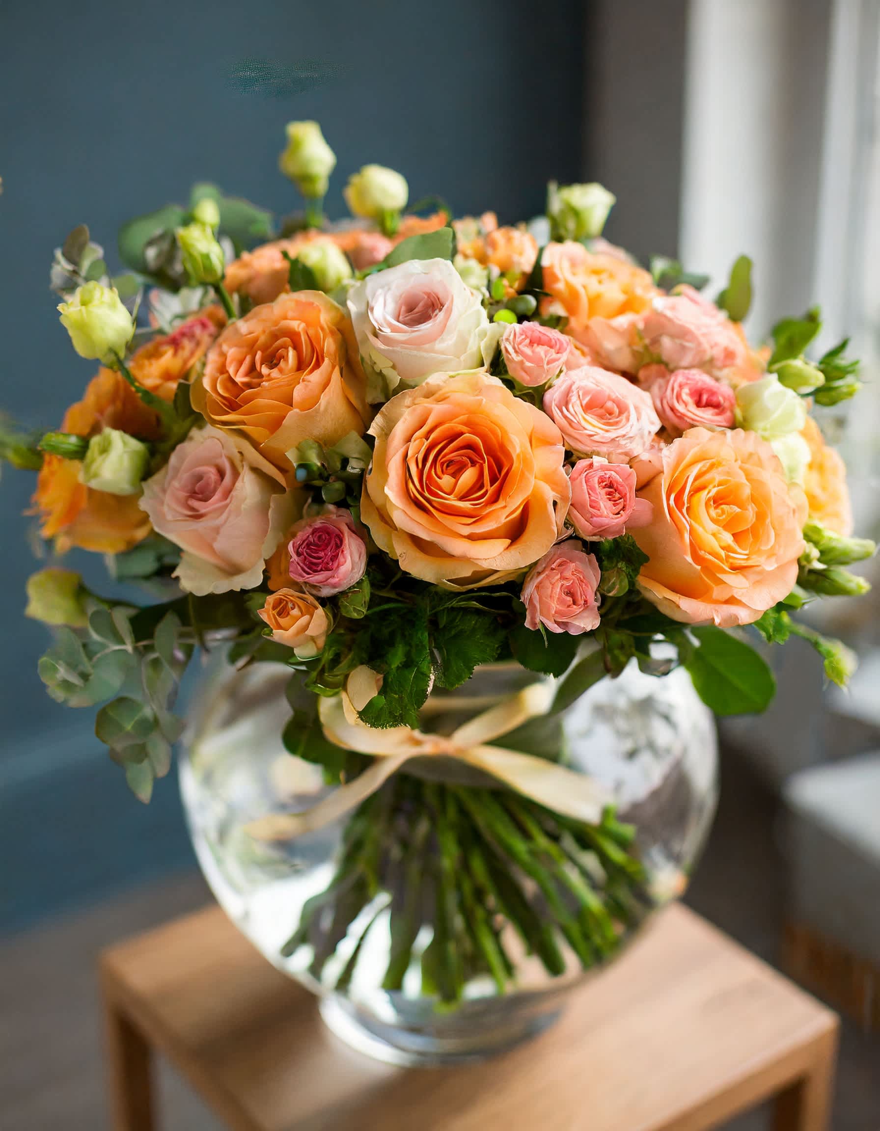 Angelenos  - Behold the elegance of flowers blending harmoniously in a light orange spectrum, forming a gentle and stunning composition. This radiant display is presented in a clear vase, embracing the beauty of sunshine.  Disclaimer: ALL IMAGES PROVIDED AT DELUXE PRICE Photos and visual presentation of the products represent an overall style, look and feel, which we may not be able to identically replicate in some instances.   Disclaimer: ALL IMAGES PROVIDED AT DELUXE PRICE Photos and visual presentation of the products represent an overall style, look and feel, which we may not be able to identically replicate in some instances.