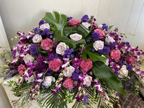 Heavenly Paradise - This vivid and tropical casket spray evokes the feelings of paradise for the soul of your loved one on to their journey to heaven.  Each floral arrangment is individually designed with a similar look and feel.