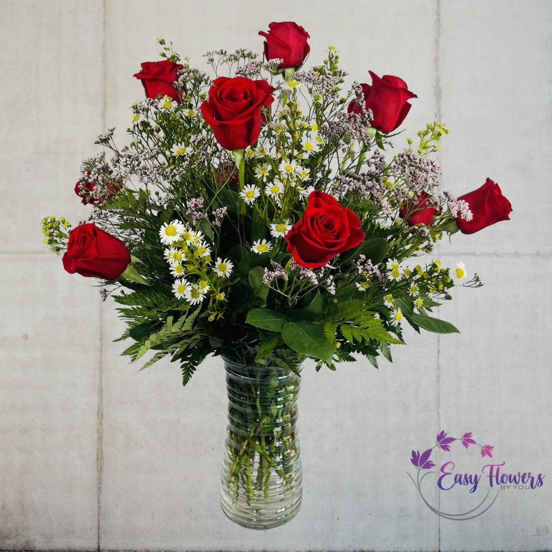 One Dozen Premium Long Stem Red Roses - Express Your Love with Stunning 24-Inch Premium Long-Stemmed Red Roses  Our elegant arrangement features rich red roses, carefully selected for their premium quality and long stems. The stunning blooms are presented in a clear glass pedestal vase, adding an extra touch of sophistication to this timeless display of love. With each petal representing a beat of your heart, these roses will help to bind your hearts together and create a lasting connection that will endure for years to come.