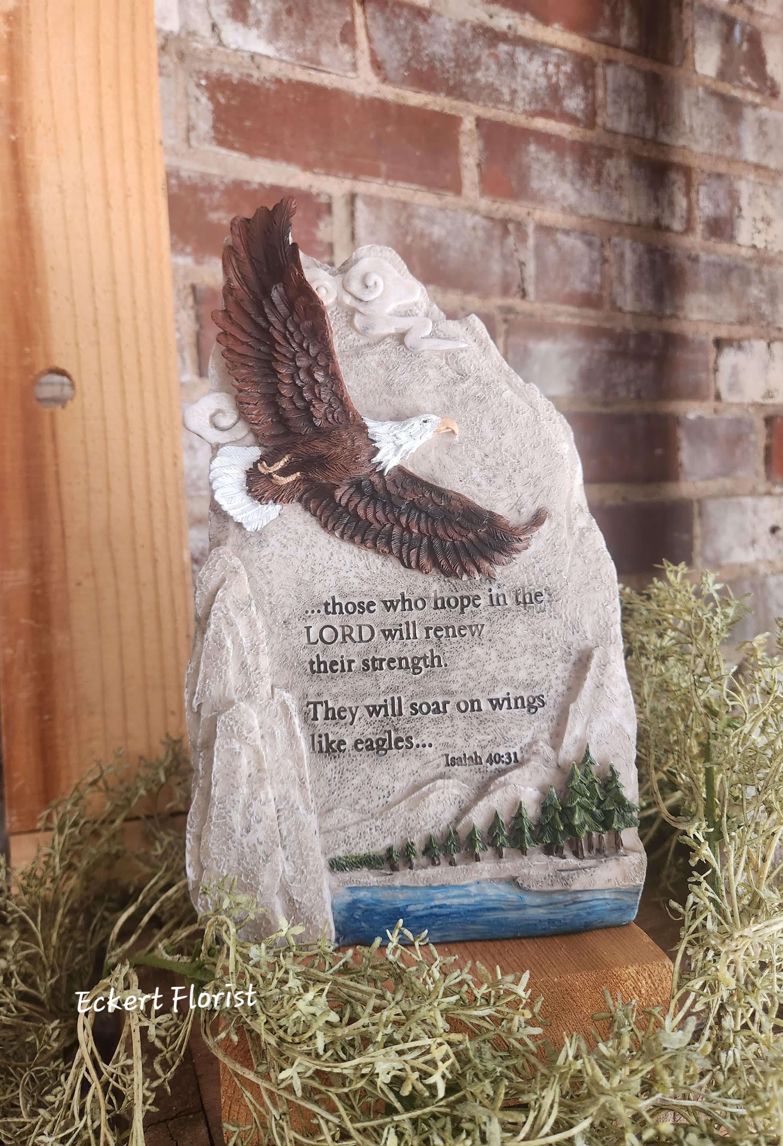 Eckert Florist's Eagle Plaque *OUR LOCAL DELIVERY ONLY Eckert Florist's Eagle Plaque *OUR LOCAL DELIVERY ONLY - This resin material plaque features a soaring eagle. Sentiment: "...those who hope in the LORD will renew their strength. They will soar on wings like eagles... Isaiah 40:31." Can be added to a green plant or fresh arrangement. See Deluxe and/or Premium upgrades. Plaque measures: 10" H x 6" W. See