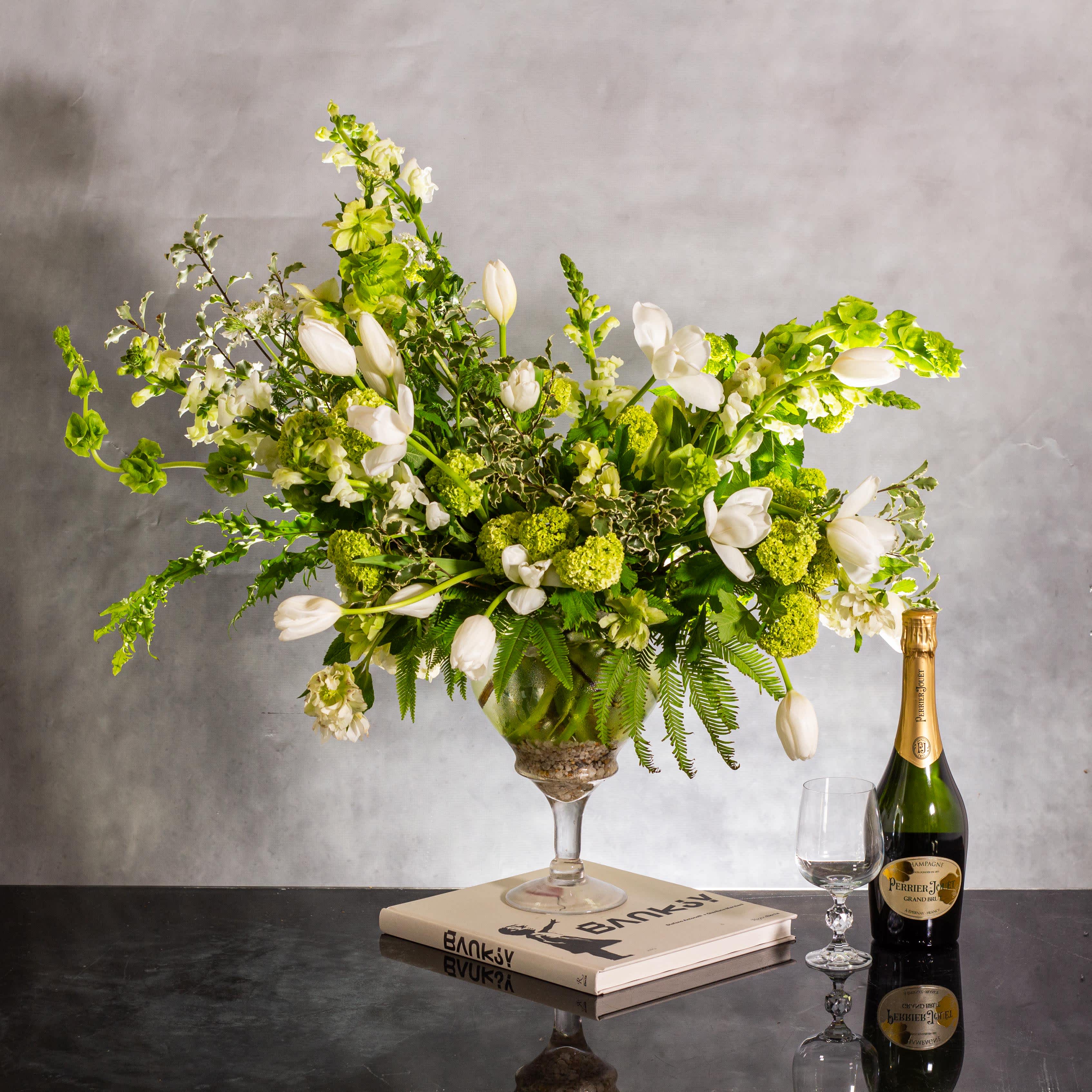 Green Serenity - Pasadena Florist - The beautiful arrangement features long white tulips, snapdragons, boulevard beautiful umbrella ferns, and vibrant greenery, creating a stunning white and green classic arrangement. Presented in a pedestal vase with an overall height of 26 inches tall and 23 inches wide, this arrangement exudes elegance and tranquility. Our Beverly Hills local florist offers same-day delivery, ensuring this classic beauty can grace your space promptly. 