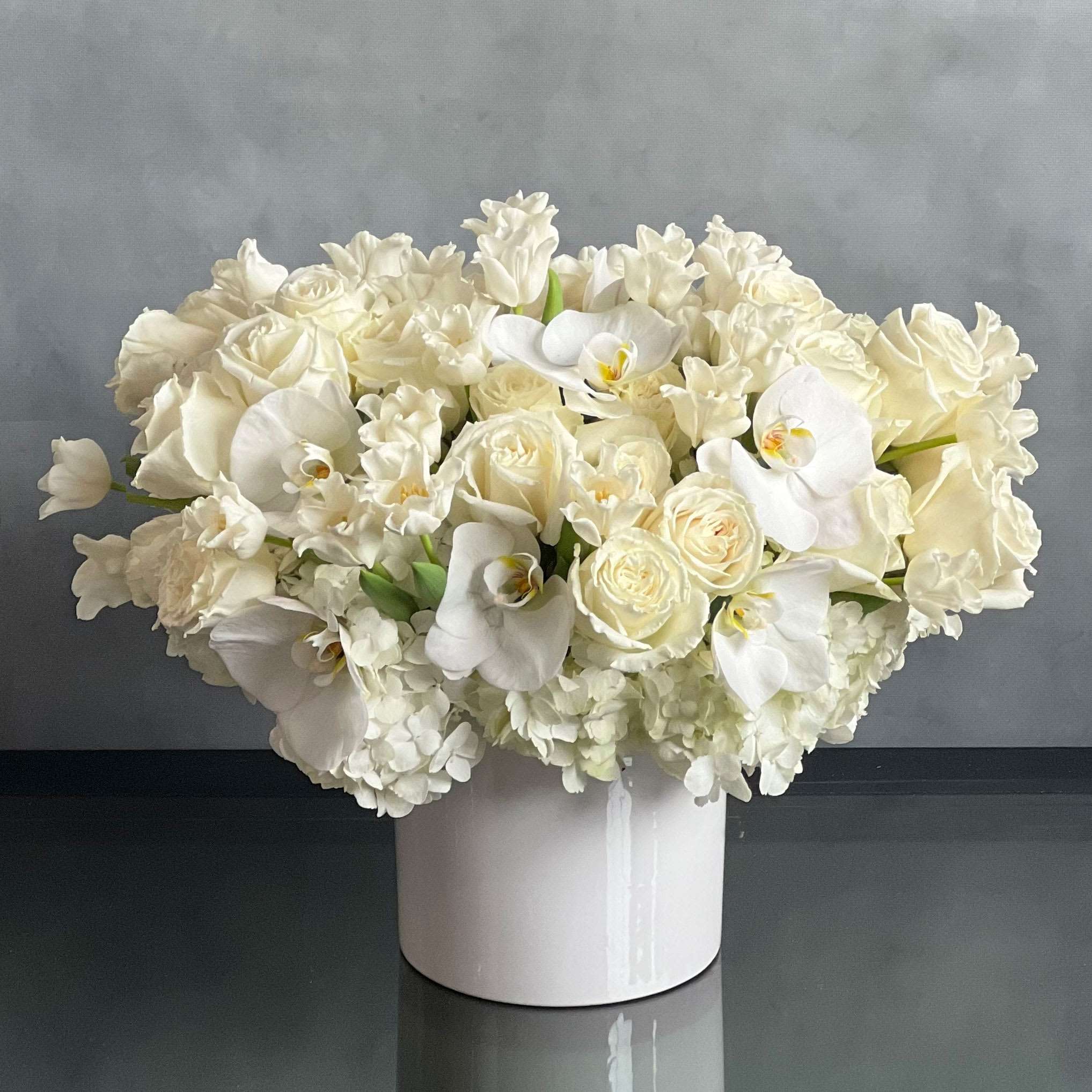 Pearl Elegance- Designers Choice - Pasadena Florist  - Sophisticated but not pretentious, strong on design and rich in detail, this arrangement is the definition of a new classic featuring a spectacular array of white seasonal floral. Depending on the season, the arrangement can include white roses, hydrangeas, orchids, tulips, anemone, hyacinths.... 
