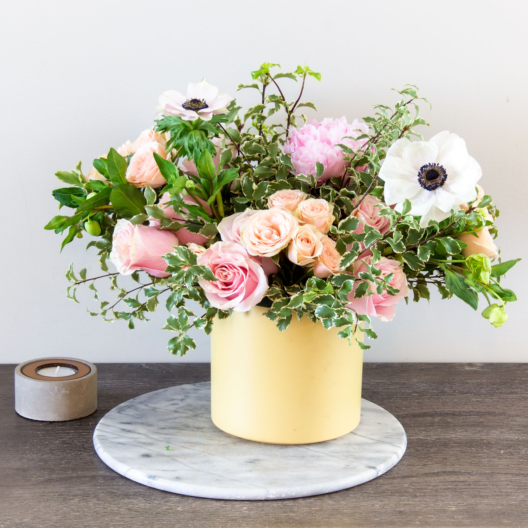 Portrait of a Lady - Pasadena Florist - Our Portrait of a Lady bouquet is a delightful selection that captures the essence of spring. Presented by Beverly Hills Florist, this arrangement offers a charming mix of peach and pink Roses, along with Anemones, beautifully arranged in a yellow container and adorned with delicate greens. This bouquet is designed to bring warmth and joy to the recipient and is available for same-day delivery in Los Angeles. Approximately measuring 12 inches round and 10 inches tall, it's a perfect gift for any occasion.