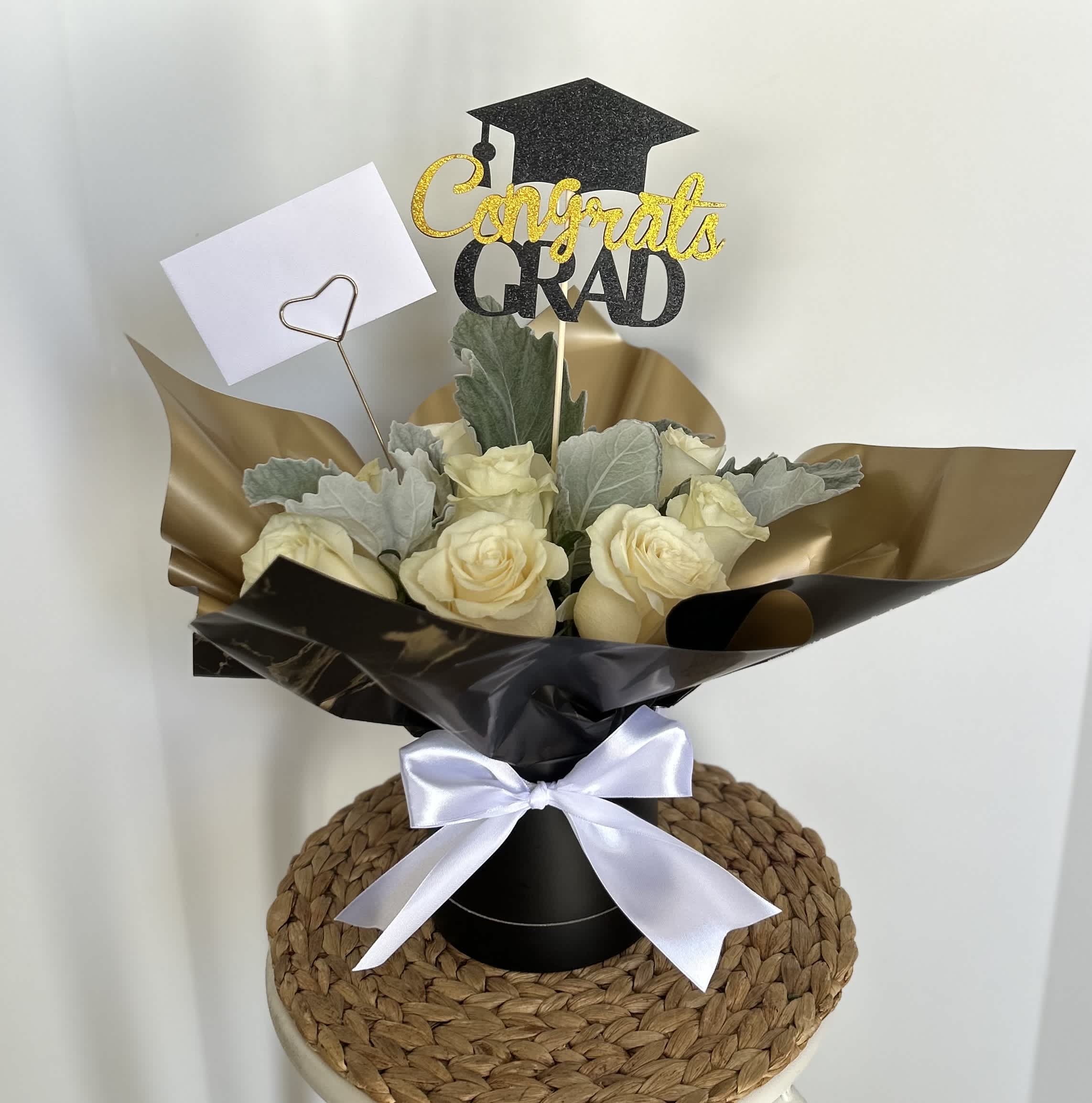 GRAD BLACK CYLINDER - Black cylinder H 4.5” with white roses and a congrats grad topper