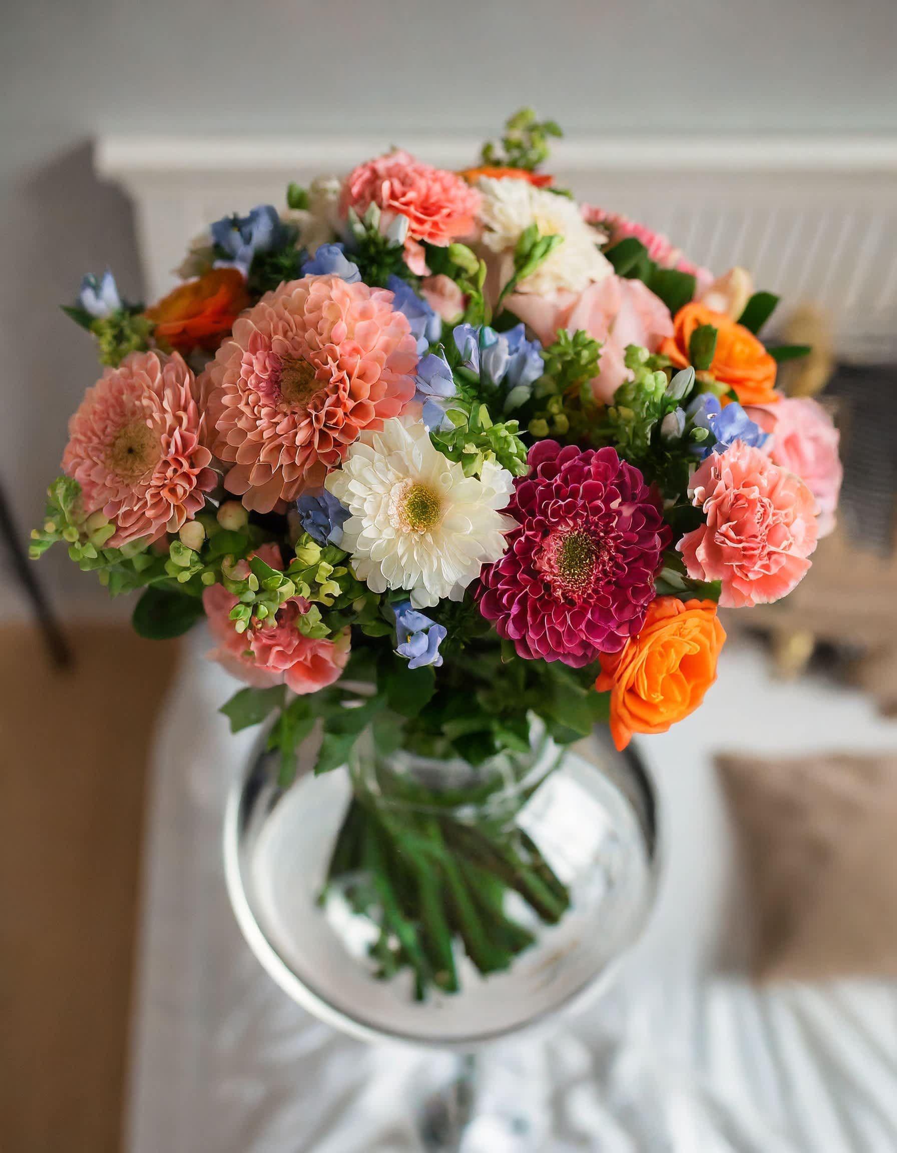 The Timeless - Immerse yourself in the allure of a bright floral fusion, where each bloom harmonizes in a gentle dance of warm hues. This composition is a testament to nature's enchanting beauty, a bouquet that speaks the language of elegance.  Disclaimer: ALL IMAGES PROVIDED AT DELUXE PRICE Photos and visual presentation of the products represent an overall style, look and feel, which we may not be able to identically replicate in some instances.