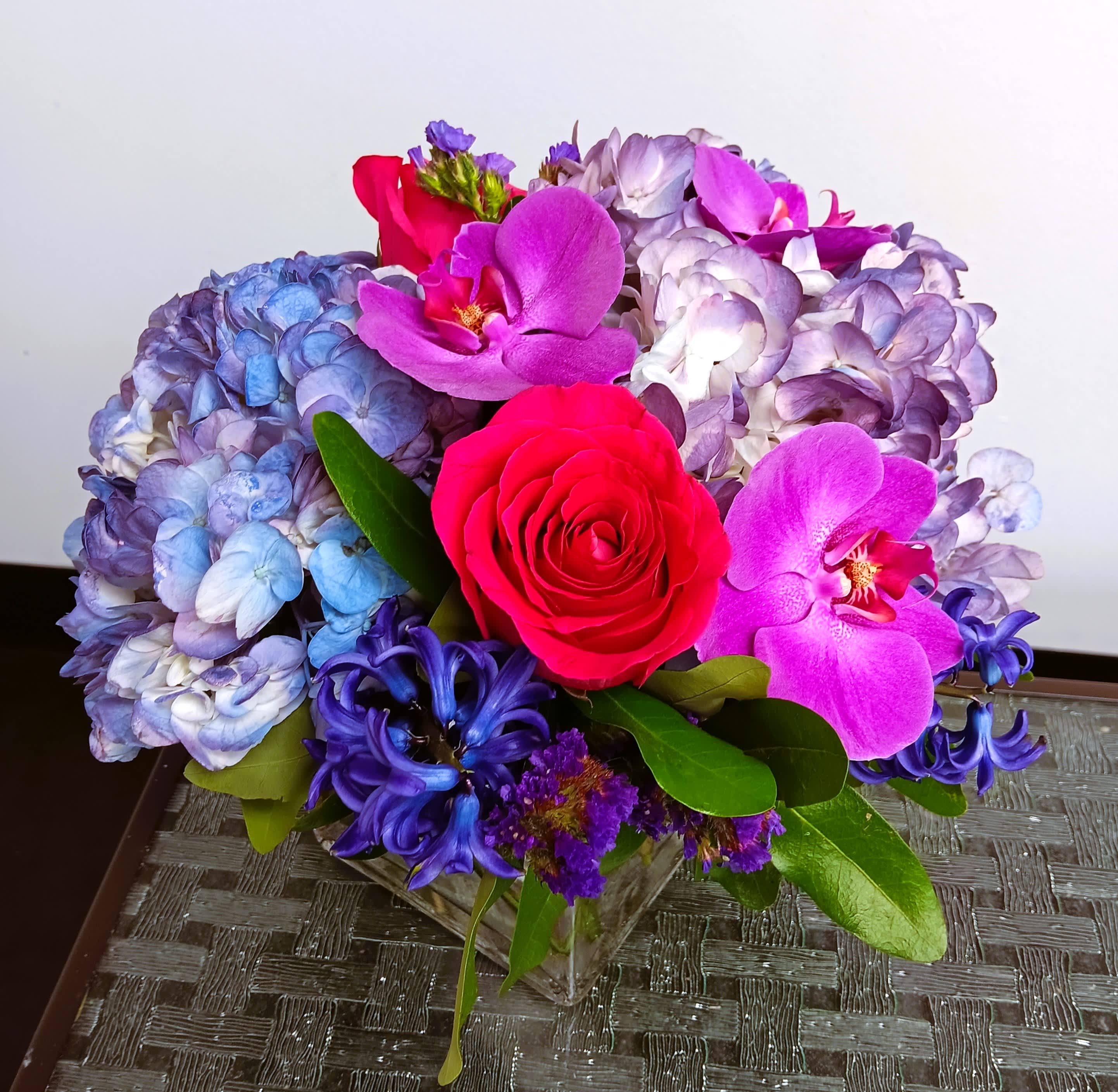 Purple Dream cube arrangement. - Fresh floral arrangement with hydrangea, roses, orchids, and other flowers.