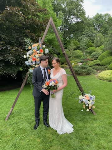 Alicia's wedding arch - Beautiful mix of orange, blue and white flowers with the fillers and greens arch decor