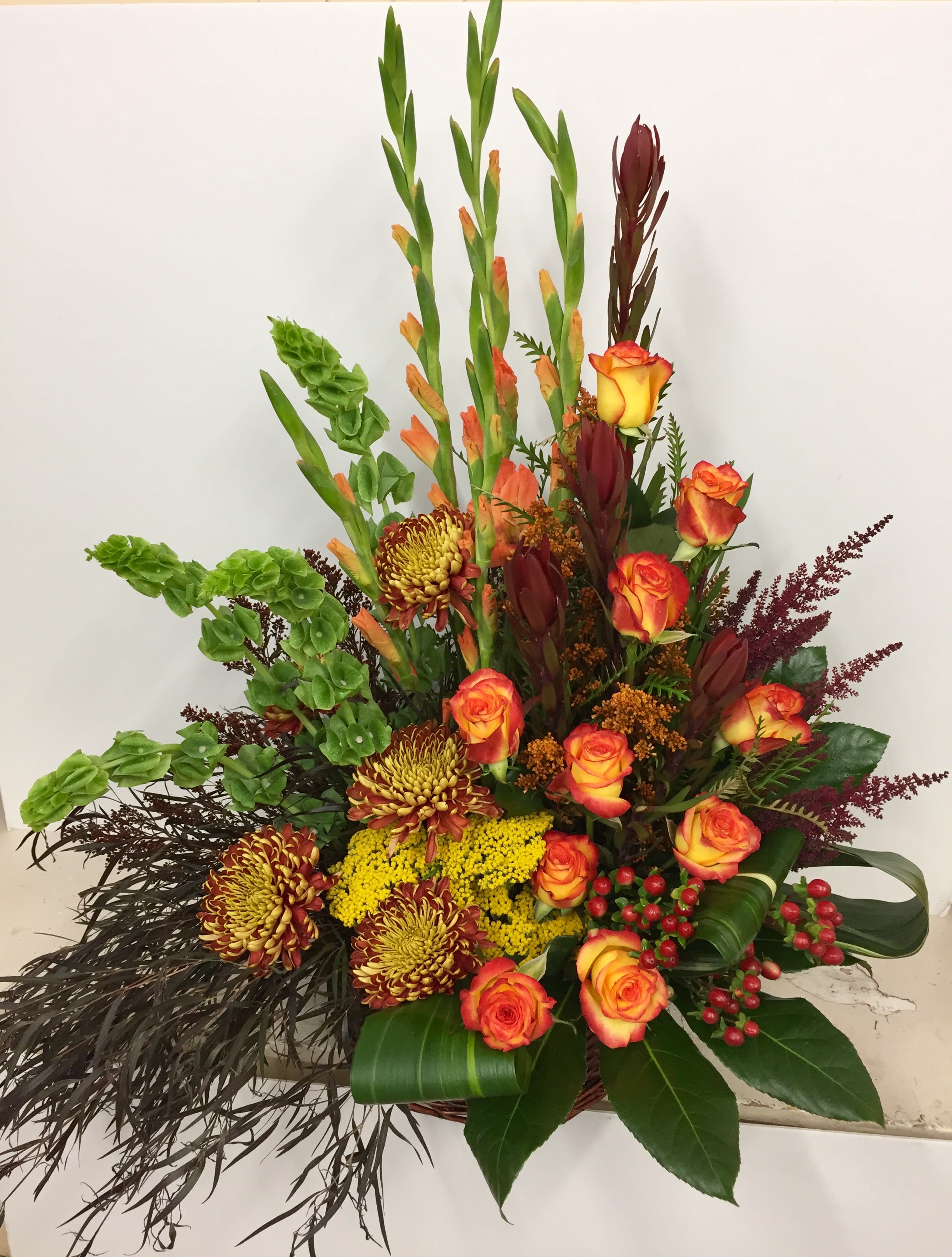 Seasonal Tribute Seasonal Tribute - Stylized bouquet with roses, bells of Ireland, astilbe. Glads, mums and yarrow