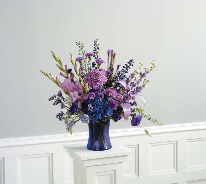 VINYARD LAVENDER VINYARD LAVENDER - BEAUTIFUL TONES ON LAVENDER/PURPLES, GREENS AND A TOUCH OF WHITE FEATURING ROSES. DISPLAYED IN A STYLISH PURPLE VASE. LOVELY WAY TO MAKE THEM SMILE.
