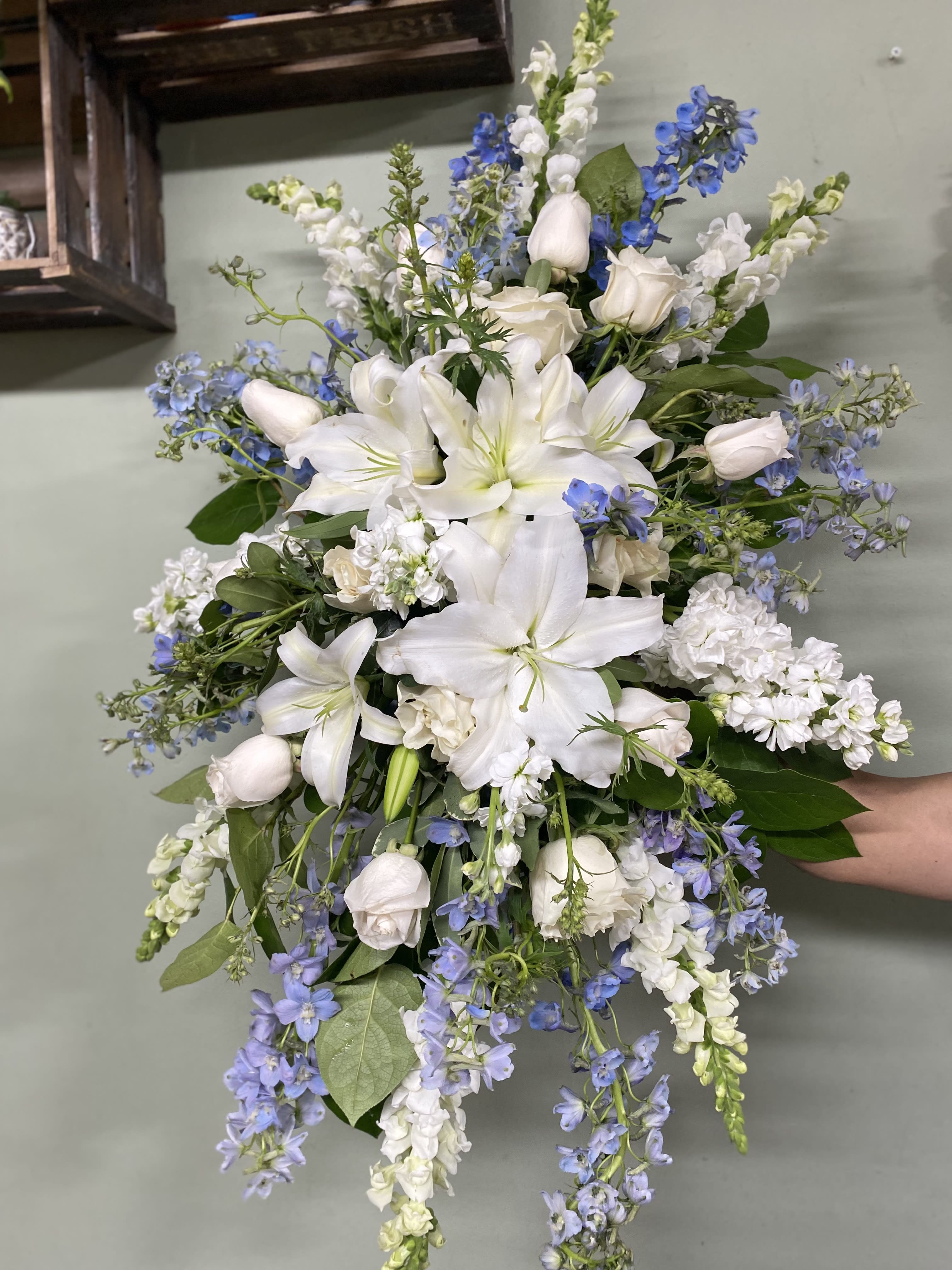 Clear Skies Spray Arrangement Clear Skies Spray Arrangement - This spray arrangement includes lilies, delphinium, snapdragons, roses, and stalks.