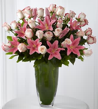 Exquisite Luxury Rose Bouquet - 30 Stems of 24-inch Premium Long-Stemmed Roses - Grant them the ultimate indulgence with a blushing bouquet of beauteous and bountiful blooms. Our finest pale pink 24-inch premium long-stemmed roses are graceful and gorgeously elegant offset by the brilliance of pink Asiatic Lilies, all lovingly situated in a unique and superior 14-inch clear glass tapered bullet vase to delight and dazzle. Includes: 30 stems of pale pink 24-inch premium long-stem roses, 4 stems of pink Asiatic Lilies, lush greens and a superior 14-inch clear glass tapered bullet vase. Approx. 30H x 23W