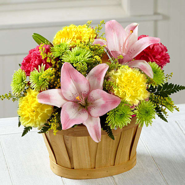 Country Time Basket - This fresh flower arrangement will persuade anyone to see the beauty of all that surrounds them. Pink Asiatic Lilies are the star of this bouquet surrounded by hot pink and yellow carnations, hot pink and yellow roses, yellow solidago, green button poms, and and fresh greens in a basket.