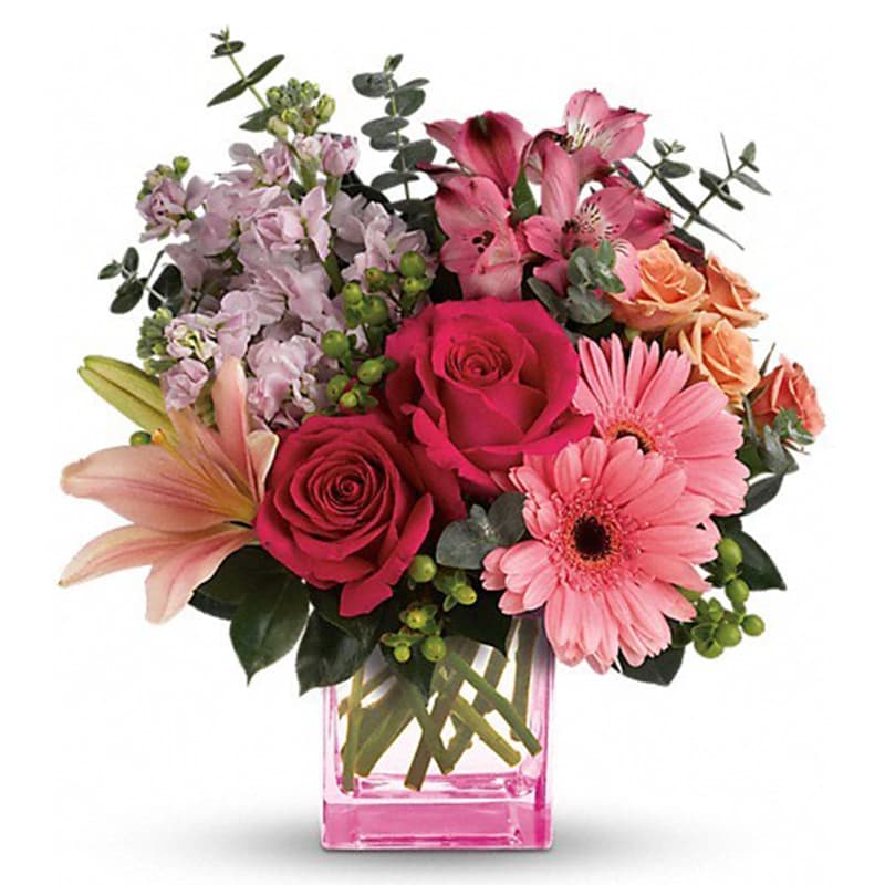 Painterly Pink Bouquet [T600-8A] - Pretty as a painter's palette! Warm, wondrous shades of pink and peach play perfectly in this feminine bouquet that's artfully arranged in a pretty pink cube vase. What a fun, fabulous way to celebrate any occasion!  This colorful arrangement includes hot pink roses, peach spray roses, pink asiatic lilies, pink gerberas, dark pink alstroemeria, pink stock, green hypericum, spiral eucalyptus and camellia leaves. Delivered in a pink cube vase.  Approximately 13&quot; W x 13 1/2&quot; H As Shown : T600-8A