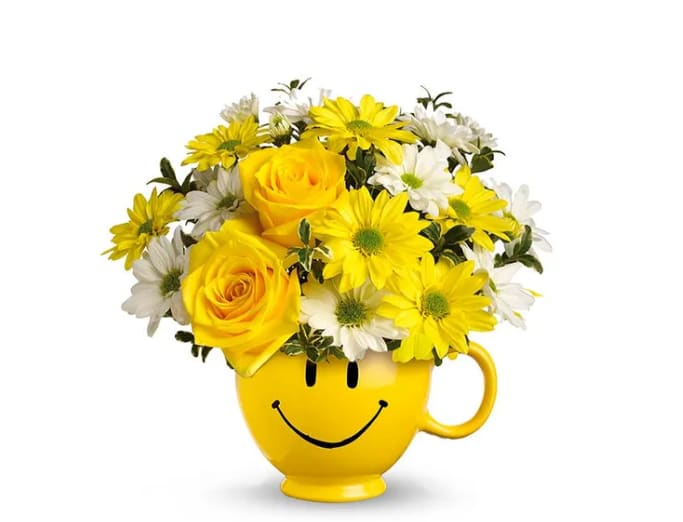 Be Happy! - Sending someone a smile is as easy as sending them this bouquet. This yellow smiley face mug is overflowing with seasonal yellow and white flowers. The best part is a reusable mug to keep the smiles coming day after day.