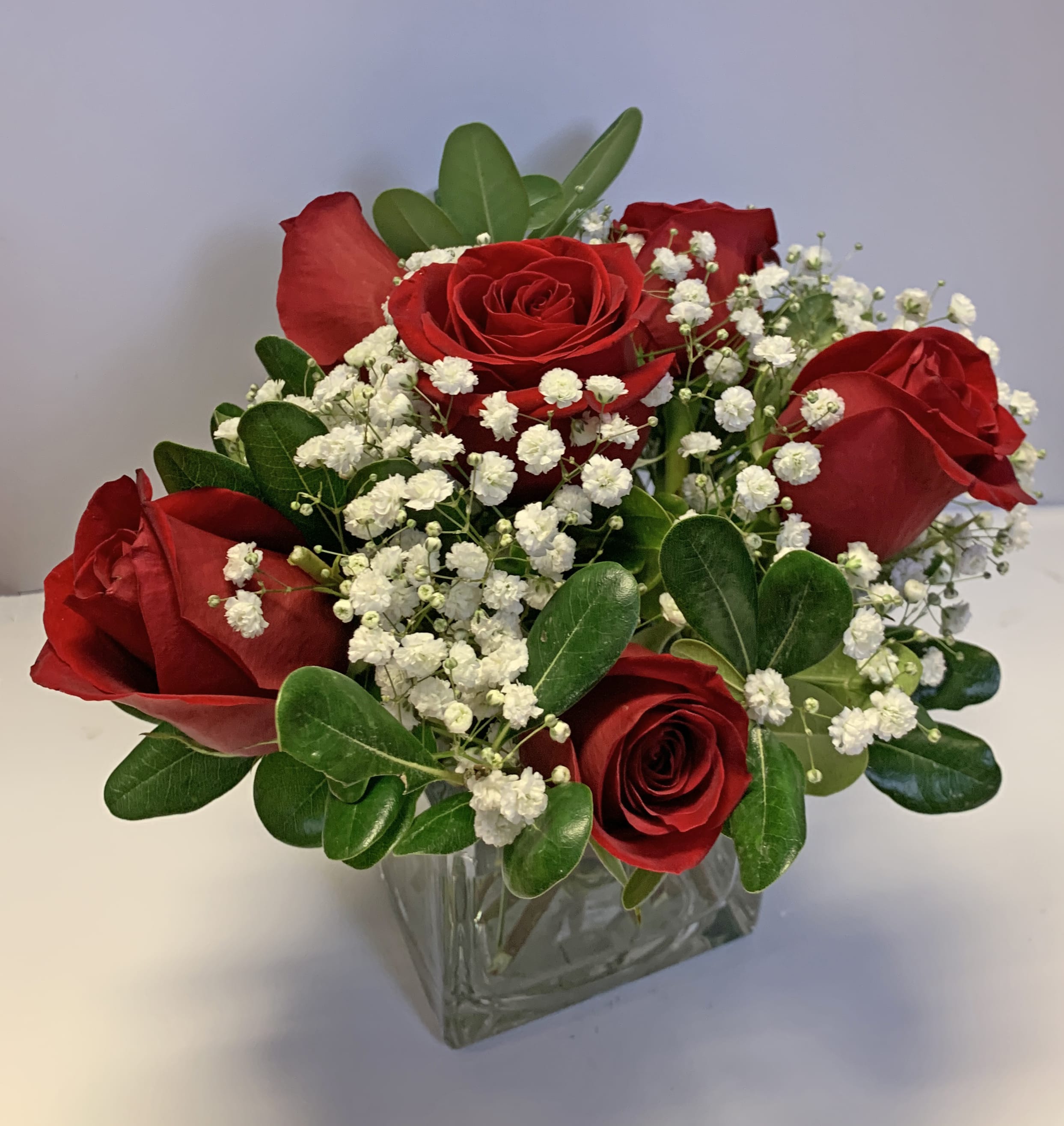 Love's Embrace Roses - SIX RED - Product ID: 10306  Embrace your feelings with a classic gift of long-stem red roses. Displayed elegantly in a glass vase and artistically designed by our select florists, these stunning roses send a memorable message to your special someone that help you express yourself perfectly, no matter what the occasion. Fresh long-stem red roses, artistically arranged by our florists with fresh gypsophila Available in arrangements of 6 roses, 3 roses or a single long-stem rose 6-stem arrangement in an 5&quot;H glass cube vase measures approximately 7.5&quot;H x 5.5&quot;L 3-stem arrangement in a glass bud vase measures approximately 16&quot;H x 4&quot;L Single-stem arrangement in a bud vase measures approximately 16&quot;H x 4&quot;L Our florists hand-design each arrangement, so colors, varieties, and container may vary due to local availability