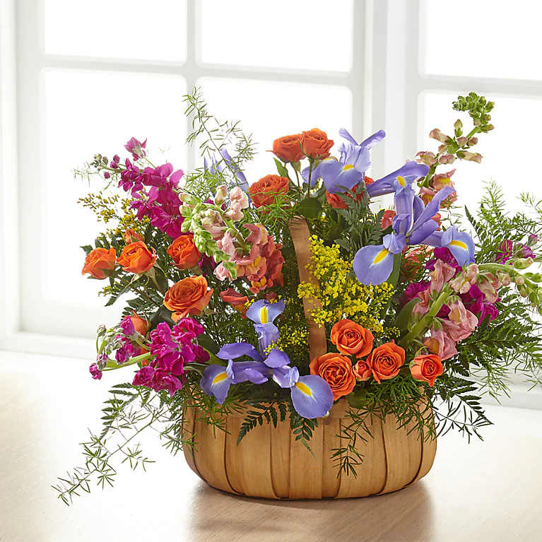 Garden of Life Basket - A gorgeous mix of bold, bright summer flowers is the best way to boost any mood. This stunning basket is designed with a colorful display of flowers to share your love and sympathy to any service or home.  Please Note: The bouquet pictured reflects our original design for this product. While we always try to follow the color palette, we may replace stems to deliver the freshest bouquet possible, and we may sometimes need to use a different basket.